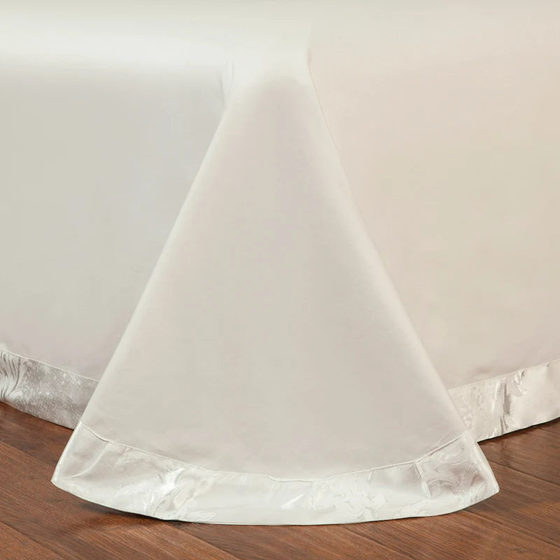 White bedskirt with lace trim on a wooden floor