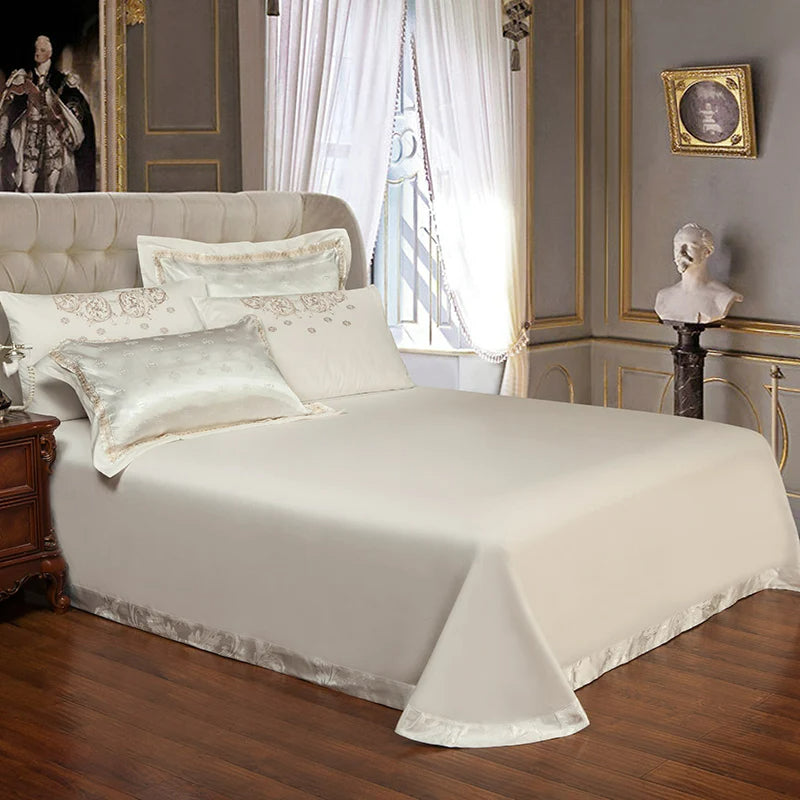 Delicate white bedding set on a bed in an elegant bedroom with classical decor.