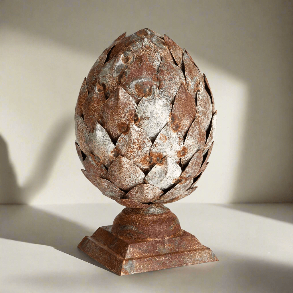 Decorative artichoke sculpture on a pedestal against a neutral background