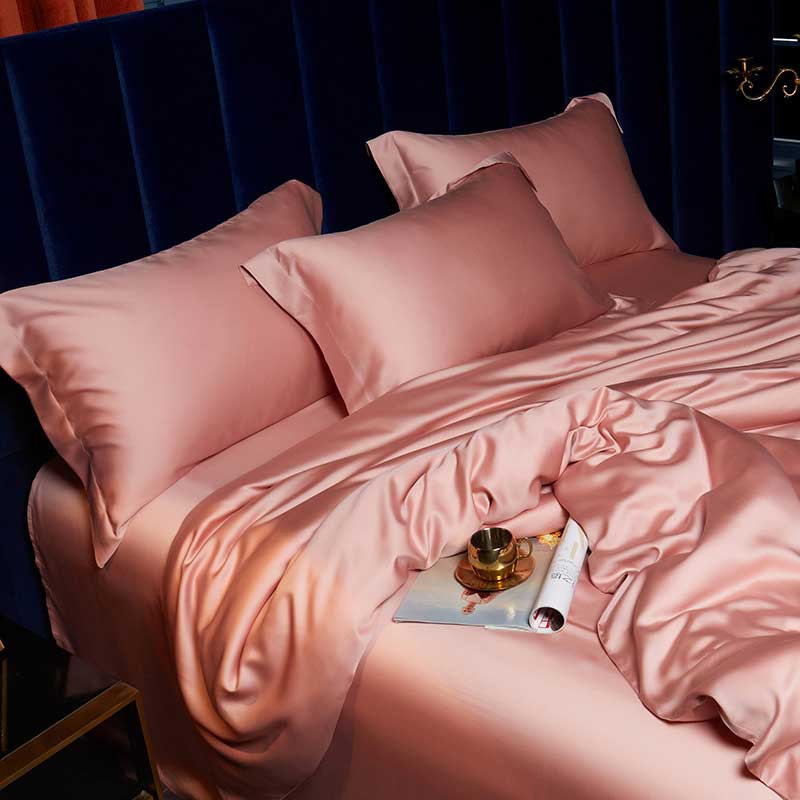 Pink satin bedding set with a dark blue headboard