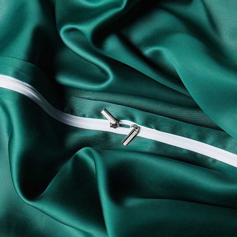 Close-up of green fabric with a white zipper