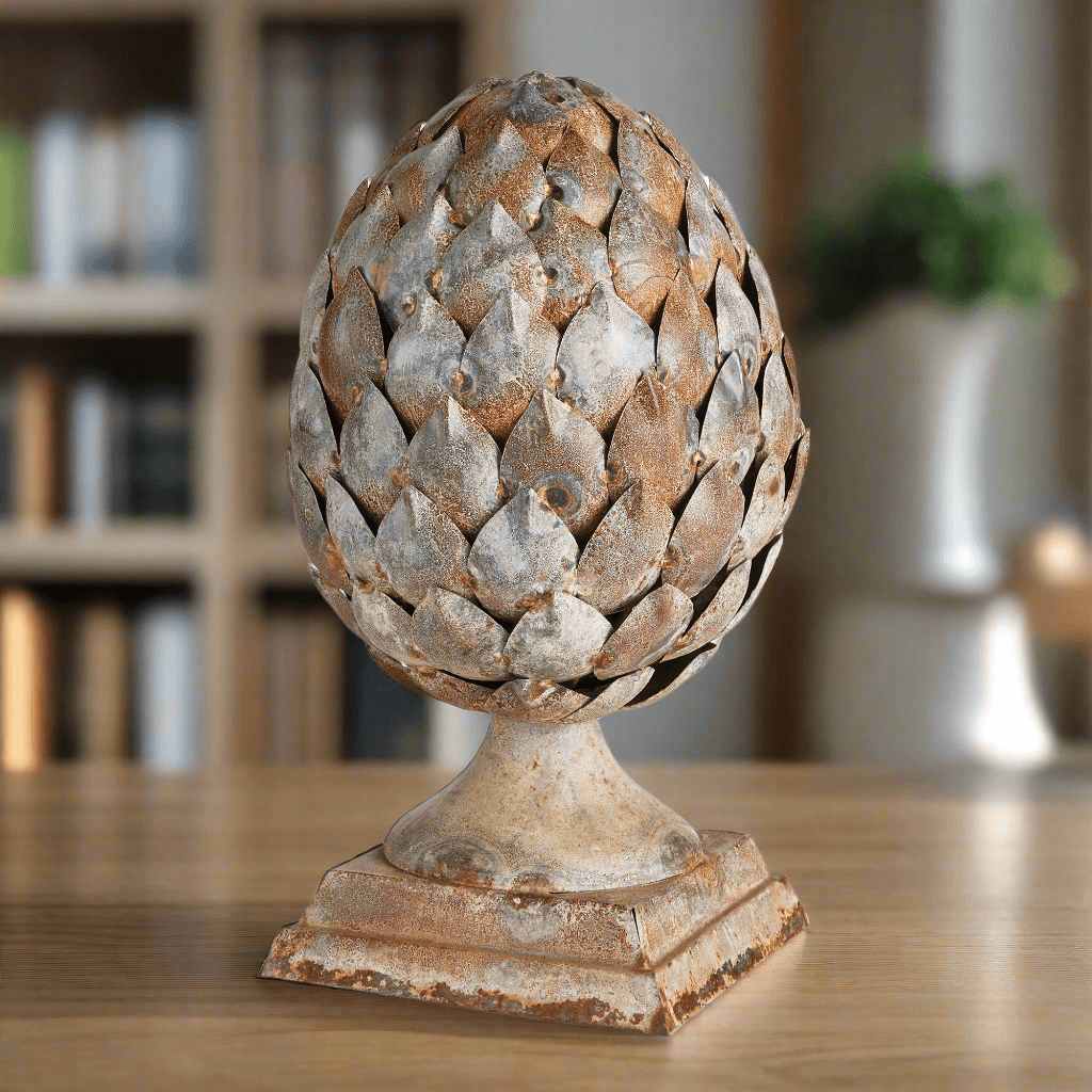 Decorative artichoke sculpture on a wooden surface with a blurred indoor background