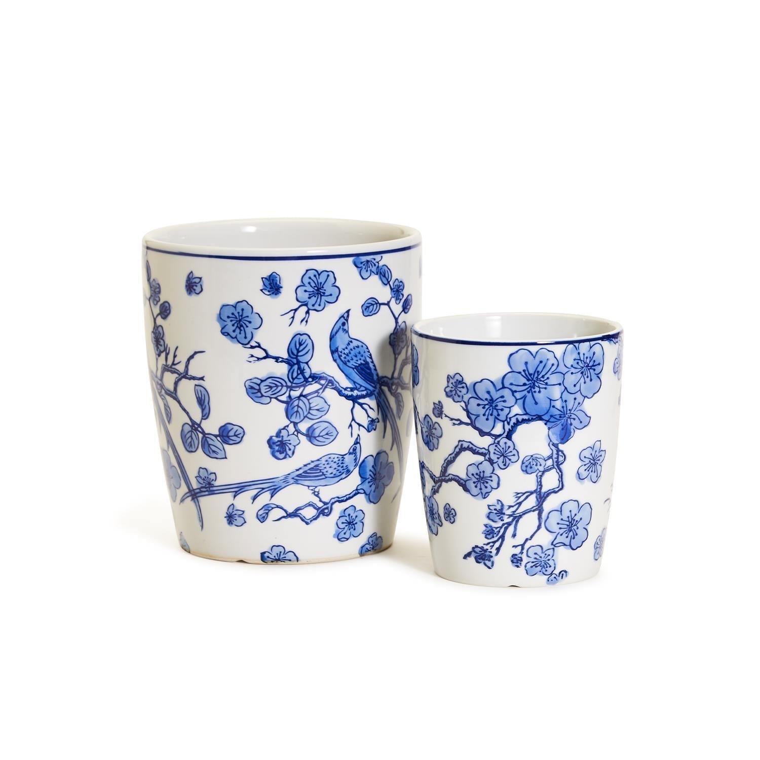 Two white ceramic planters with blue floral and bird patterns on a white background