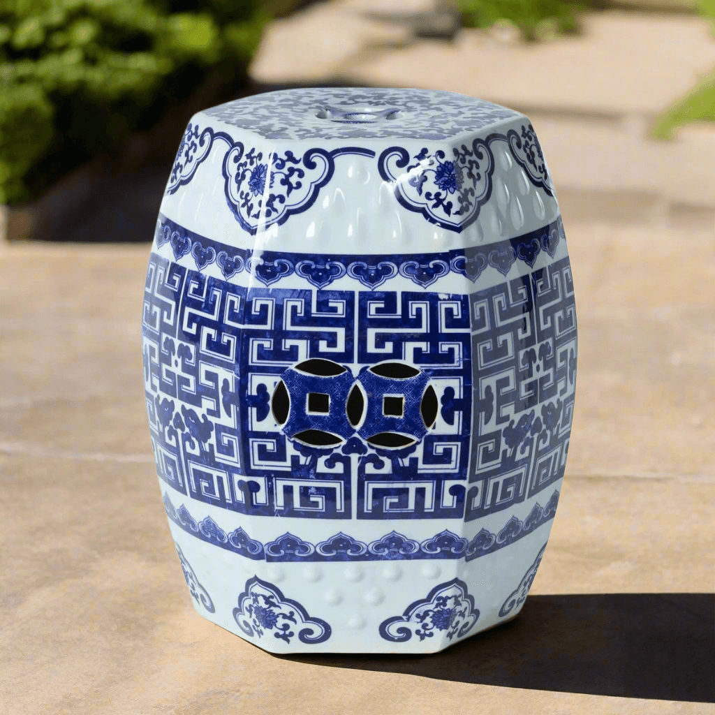 Blue and white chinoiserie ceramic garden stool with intricate patterns on a stone surface.