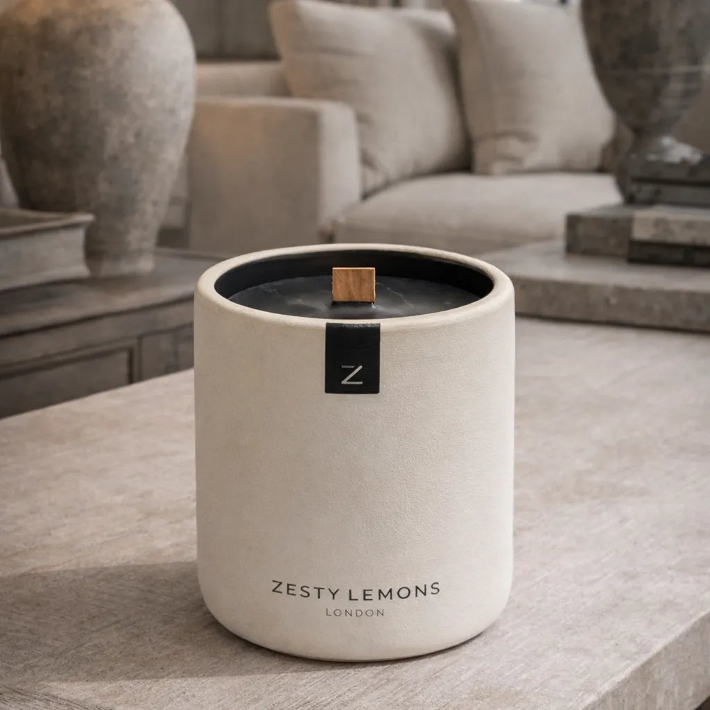 Candle labeled 'Zesty Lemons London' on a surface with a blurred background