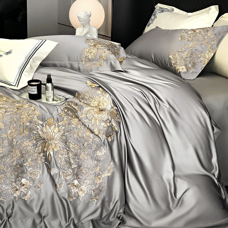 Gray satin bedding set featuring a gold butterfly with floral embroidery on a bed.
