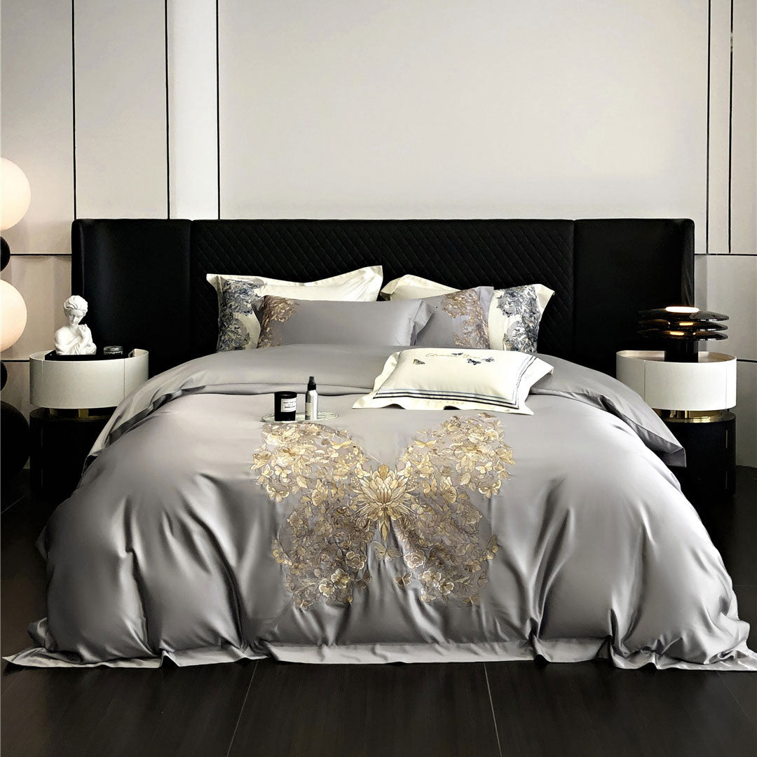 Gray bedspread with gold butterfly design on a bed in a modern bedroom.