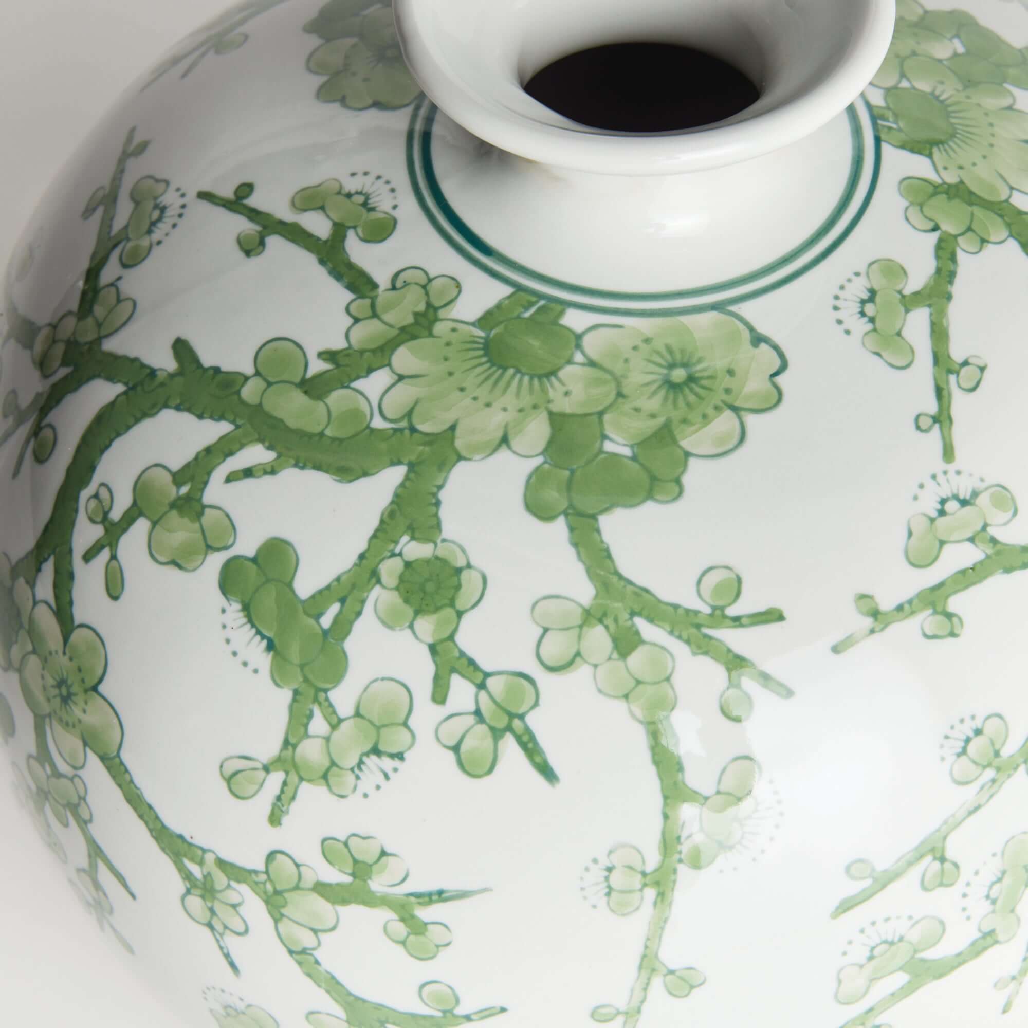 Close up of a 12 inch green and white botanical chinoiserie porcelain vase vintage style with hand painted plum blossoms.