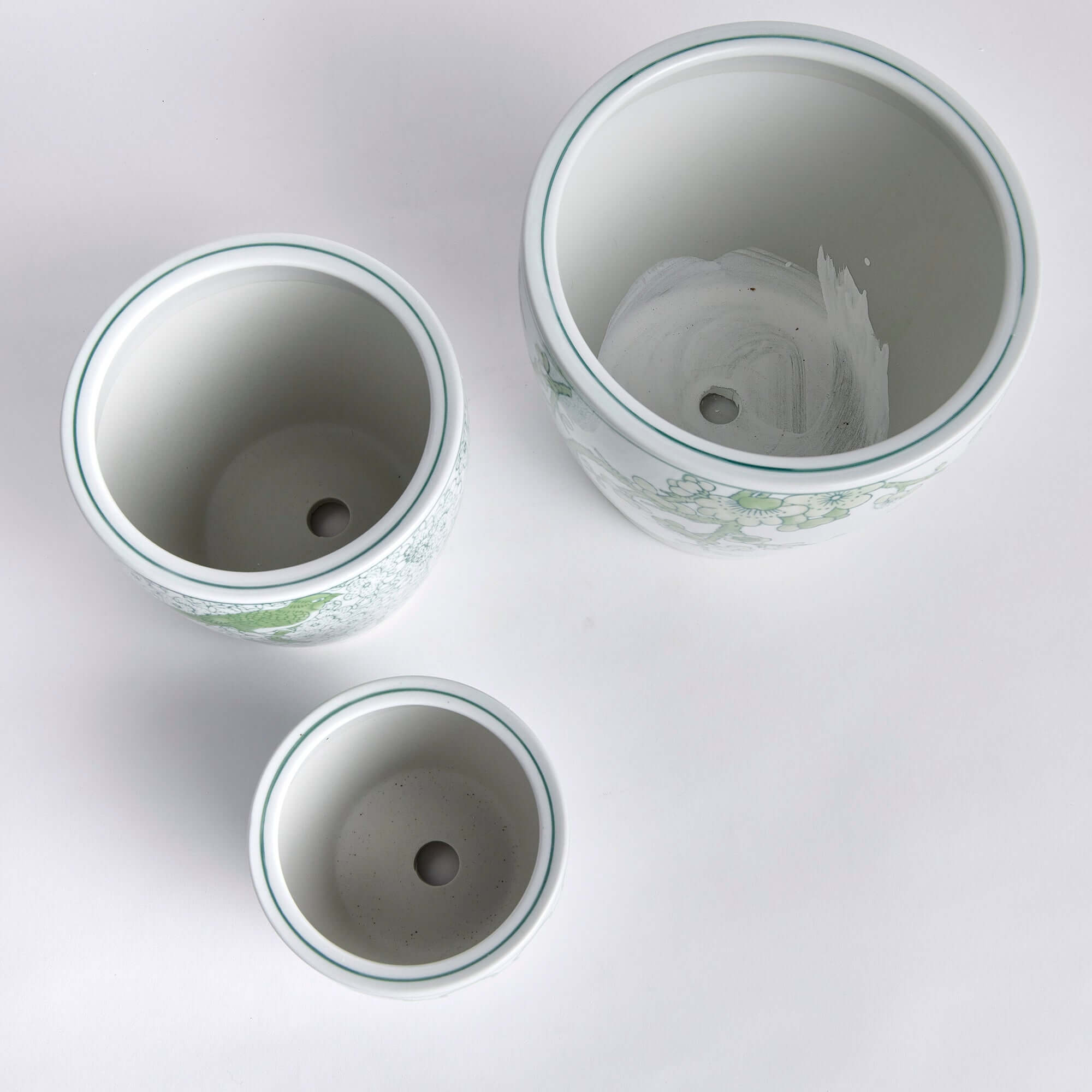 Three ceramic pots of different sizes on a white background