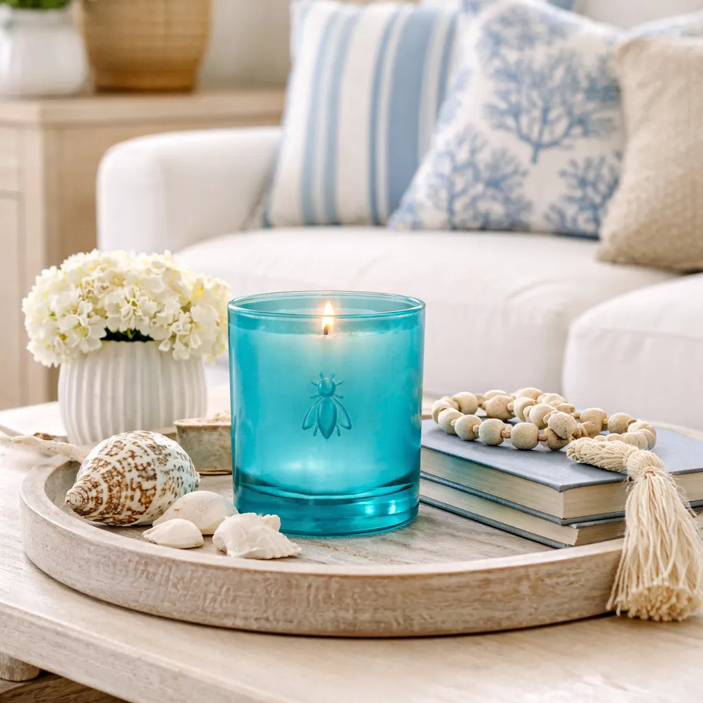 Blue La Rochere candle on a wooden tray with decorative items in a living room setting