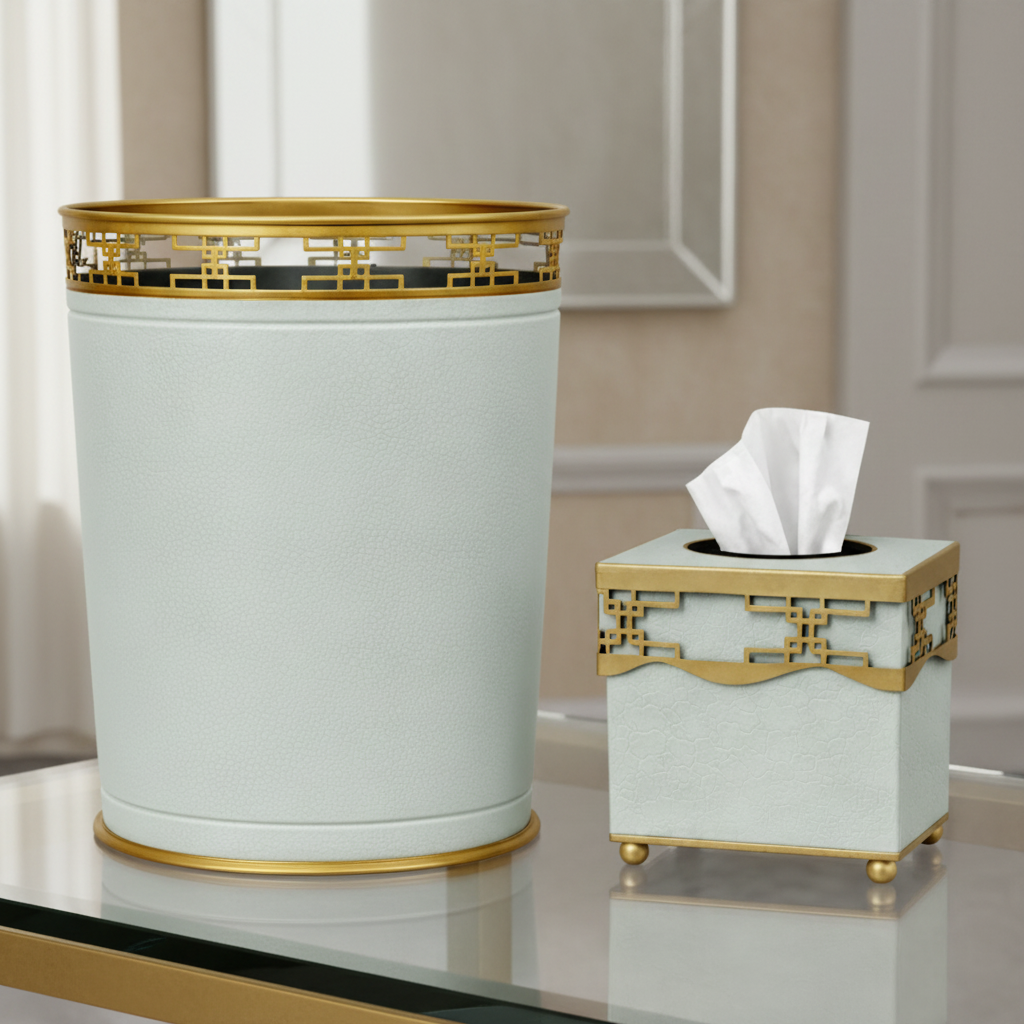 Decorative trash can and tissue holder with gold accents on a reflective surface.