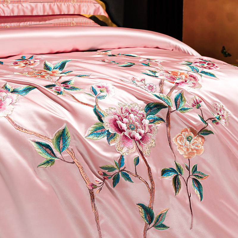 Pink satin fabric with floral embroidery on a bed