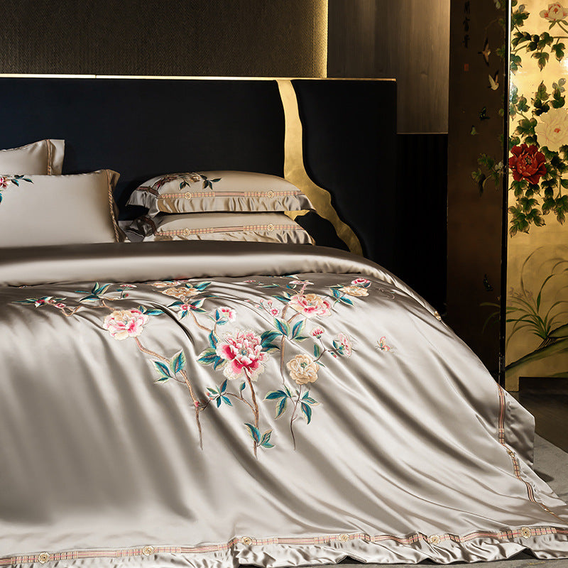Floral embroidered bedding set on a bed with a decorative headboard.