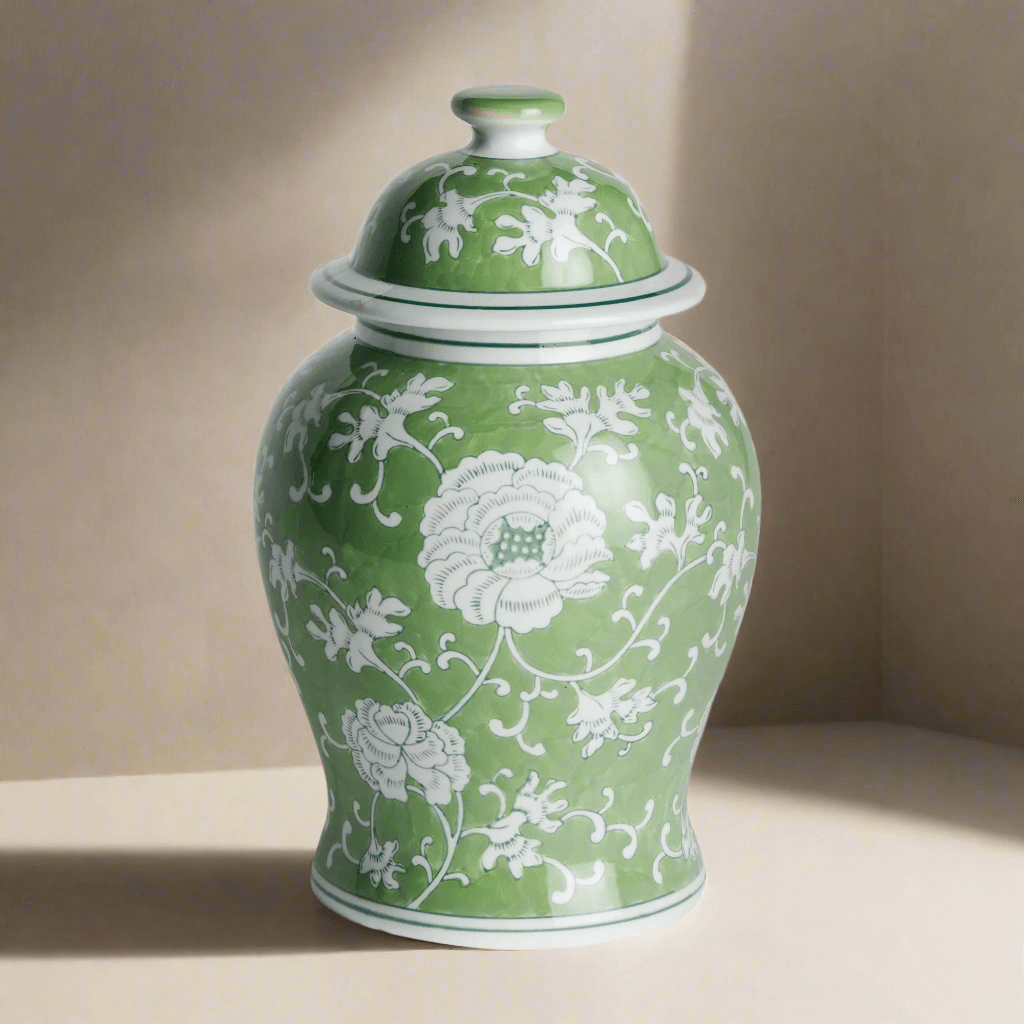Green ceramic jar with white floral patterns on a beige background