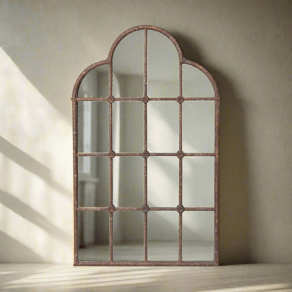 Arched metal window pane mirror with grid design on a beige wall