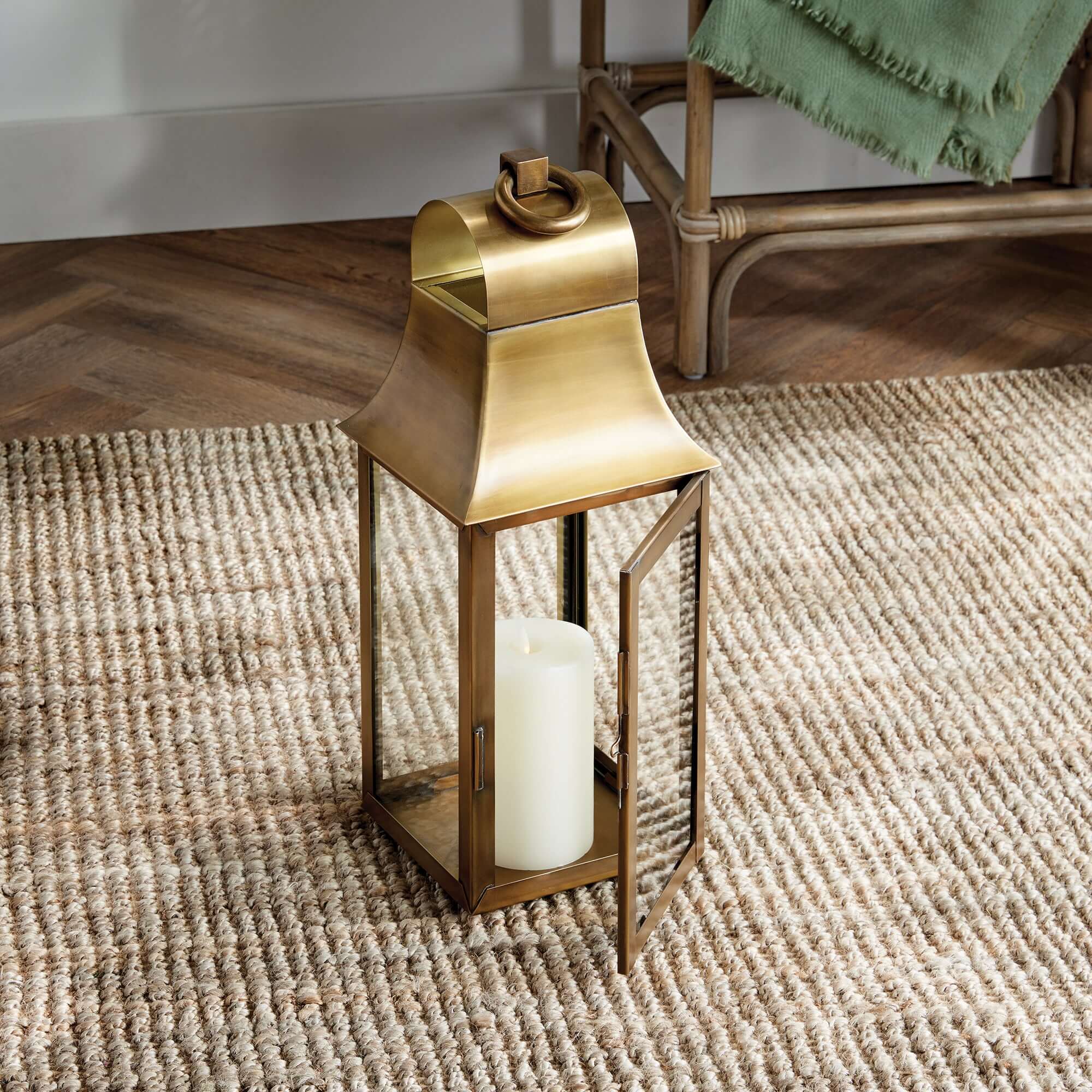 Brass lantern with a candle on a textured rug