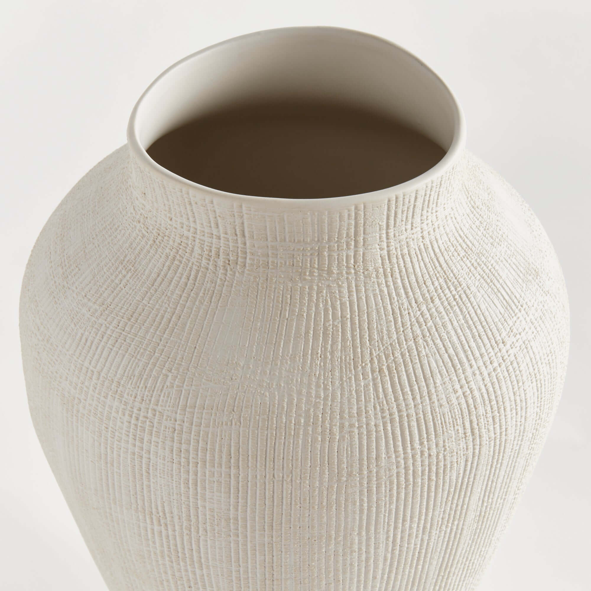 Textured beige ceramic vase on a light gray background