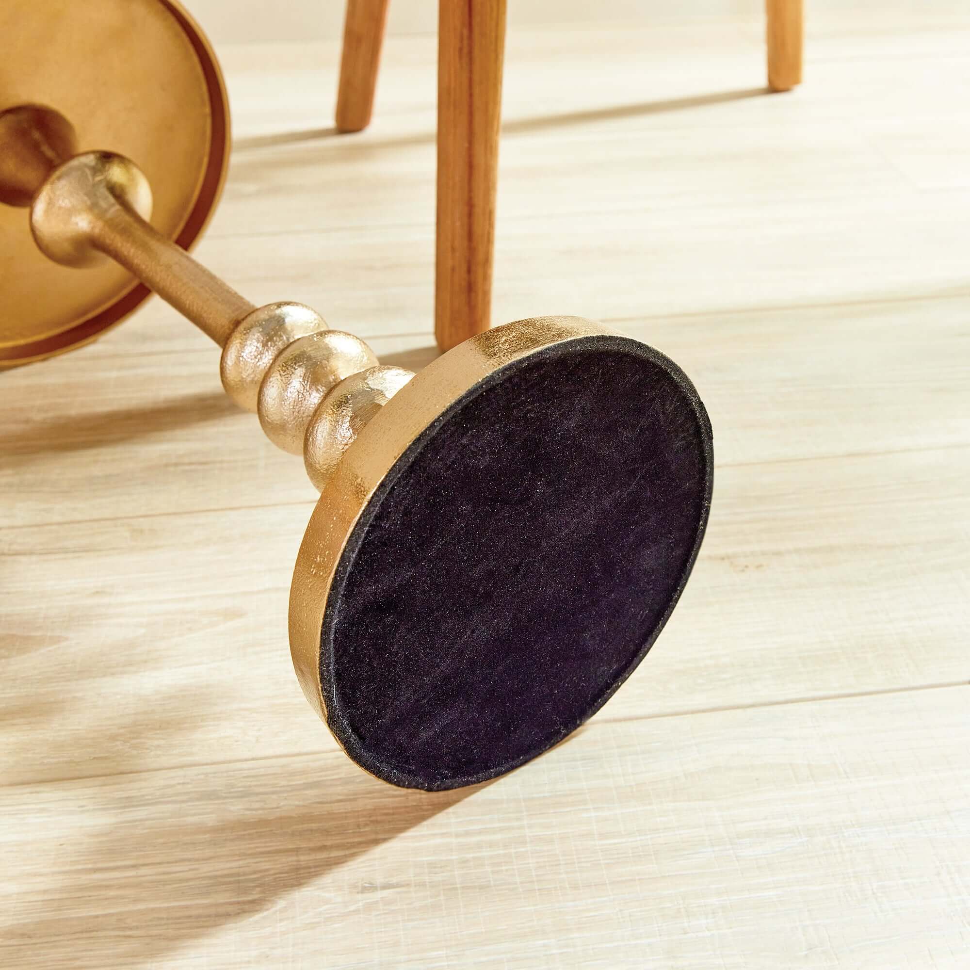 Close-up of a gold door handle with a black doorknob on a wooden surface