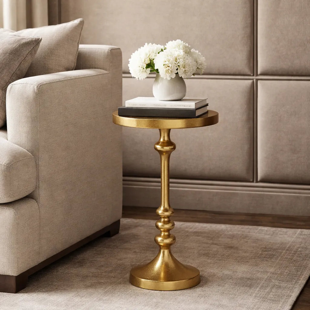 Gold side table with a vase of white flowers in a living room setting