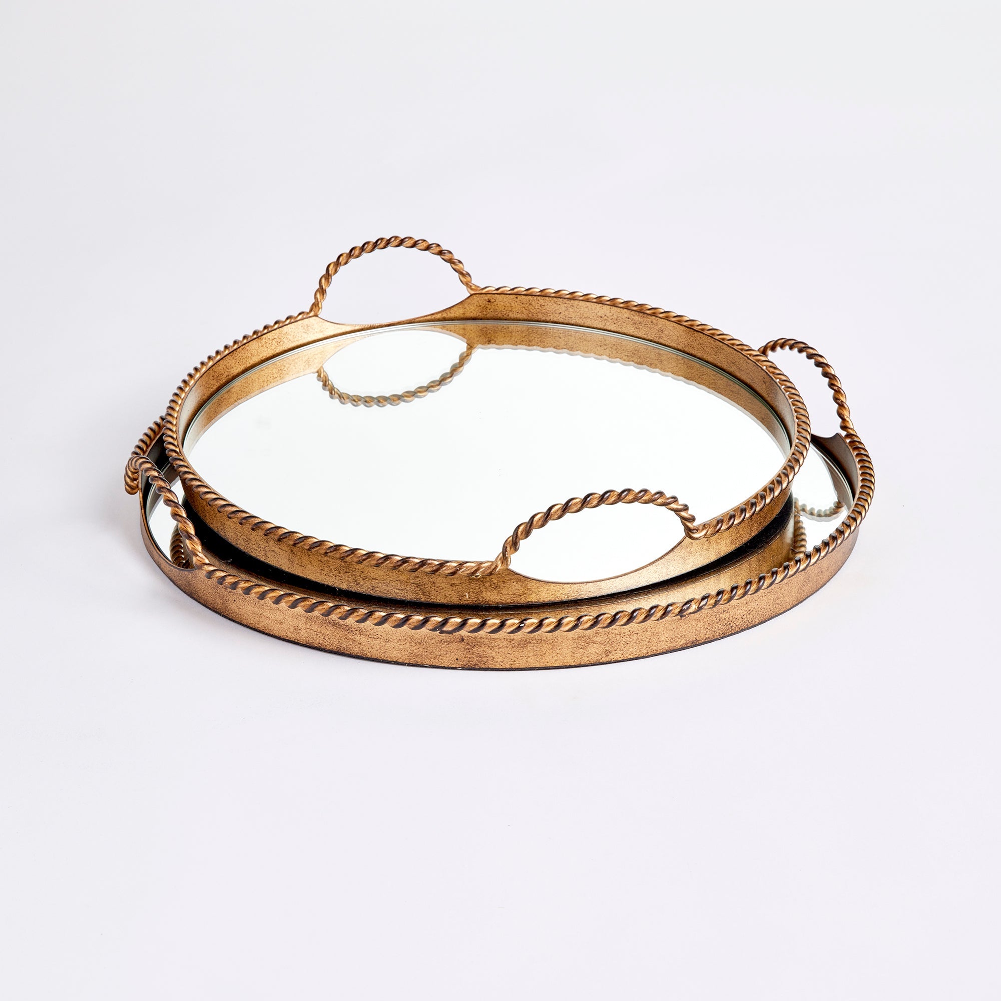 Set of two gold decorative trays with handles on a white background