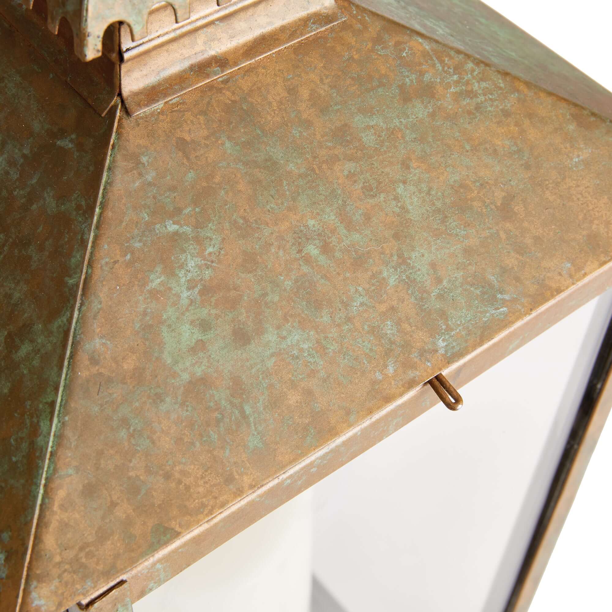 Close-up of a metal surface with a textured, patinated finish on a white background