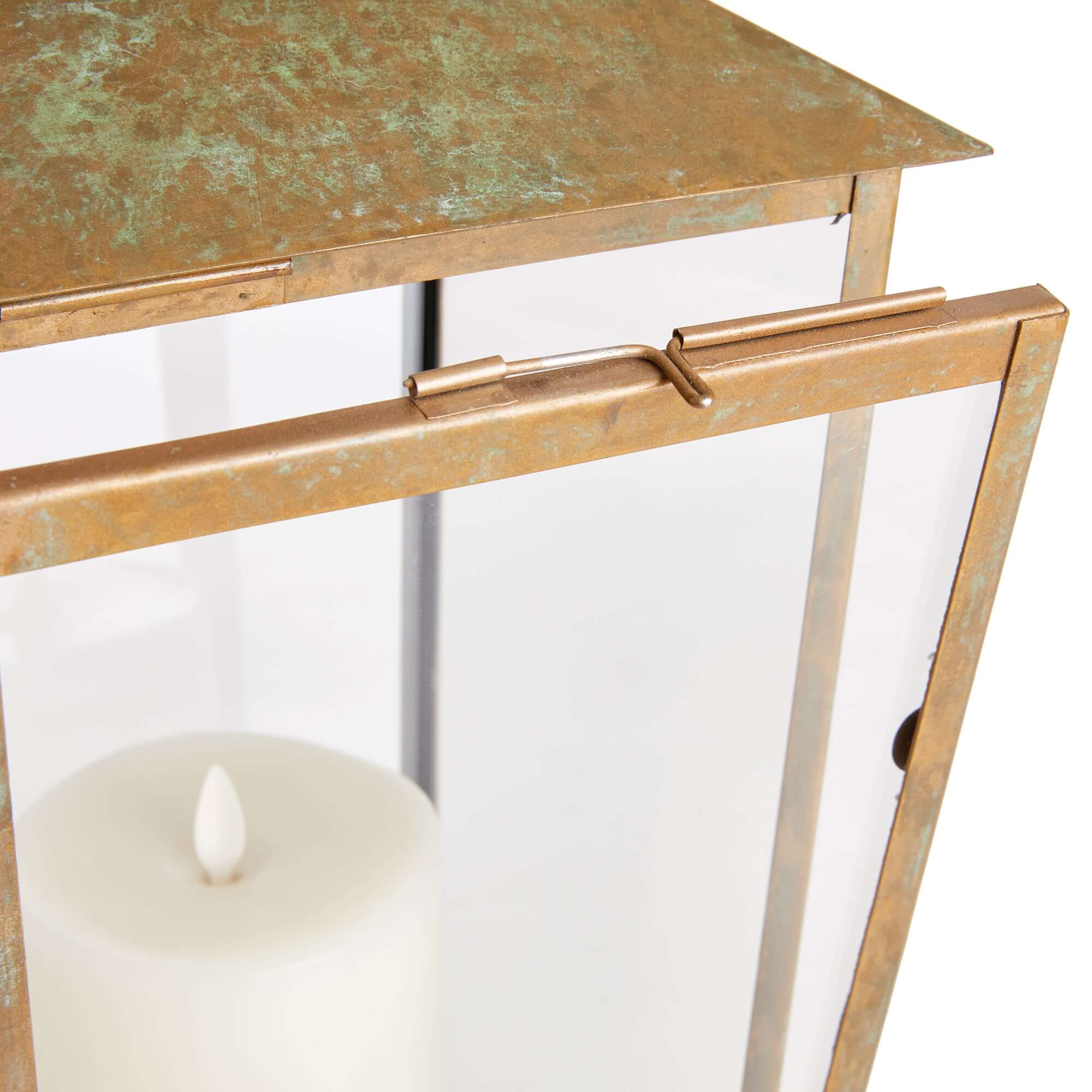 Close up of a decorative lantern with a metallic finish and a candle inside.