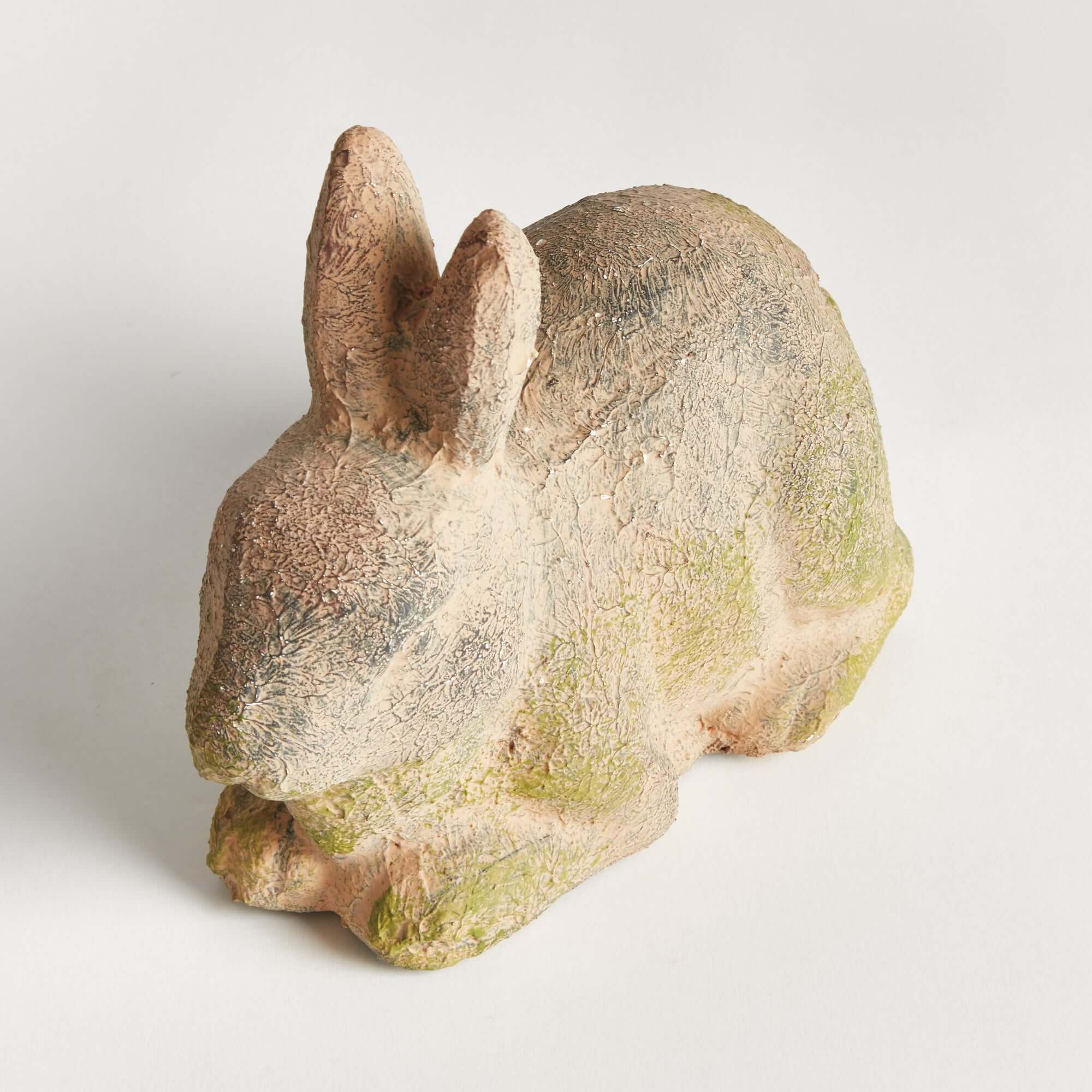 Stone rabbit sculpture on a light gray background