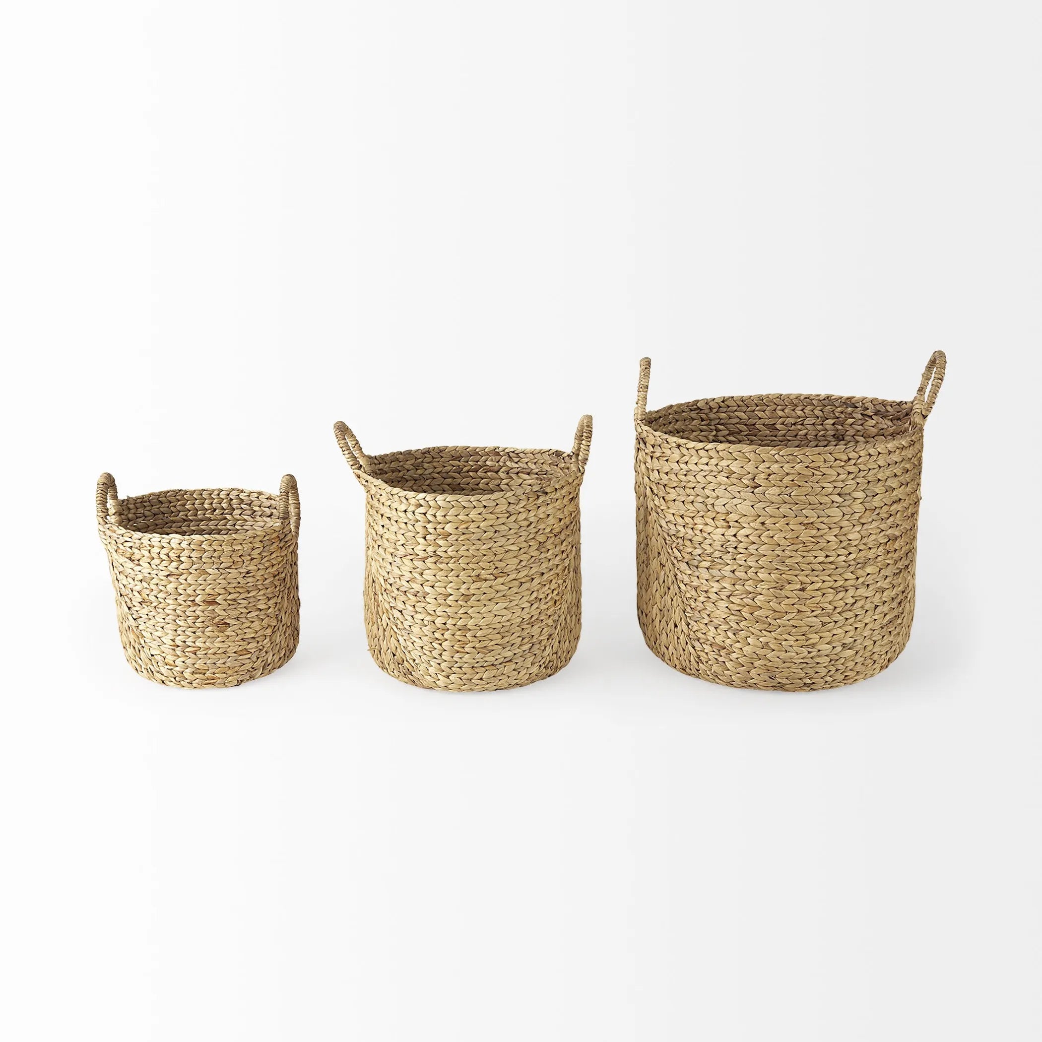 Front view of three woven baskets of different sizes on a white background