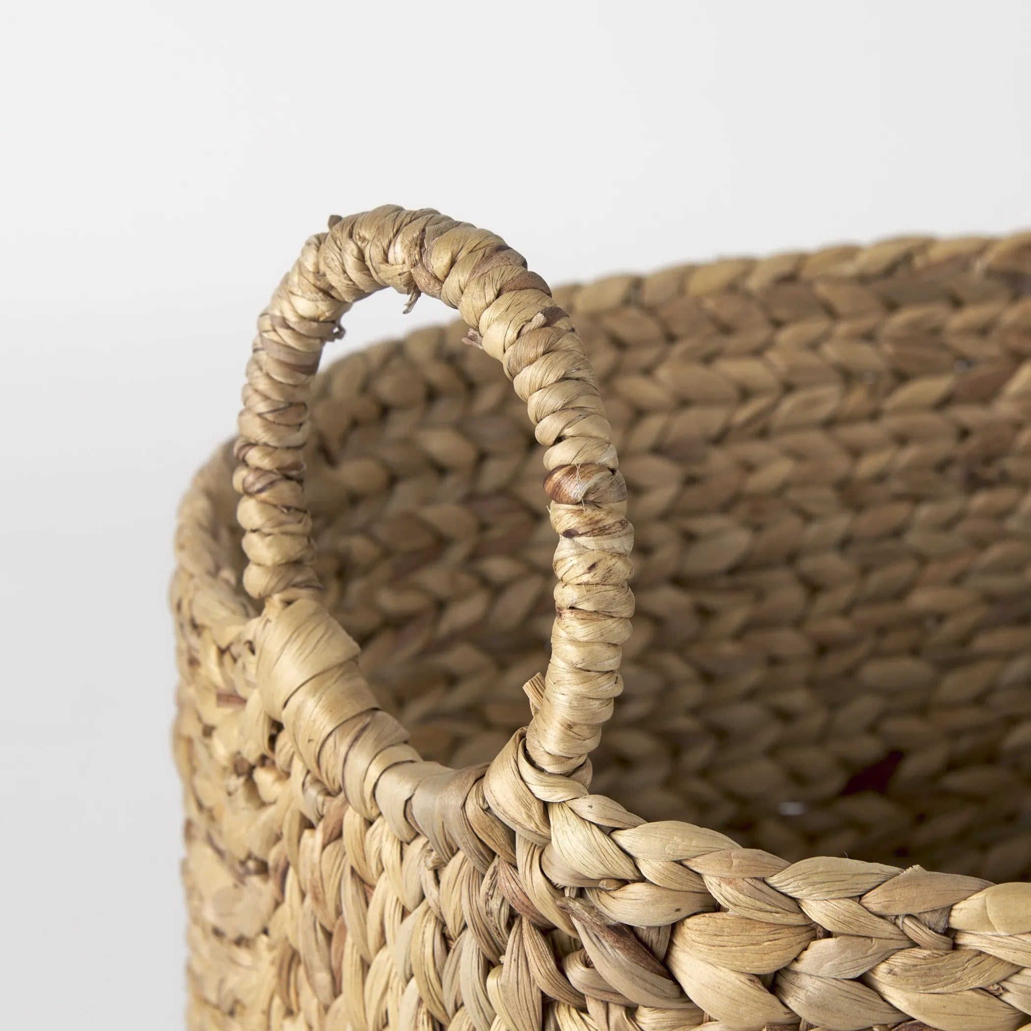 Close-up of a woven basket with a handle on a light background