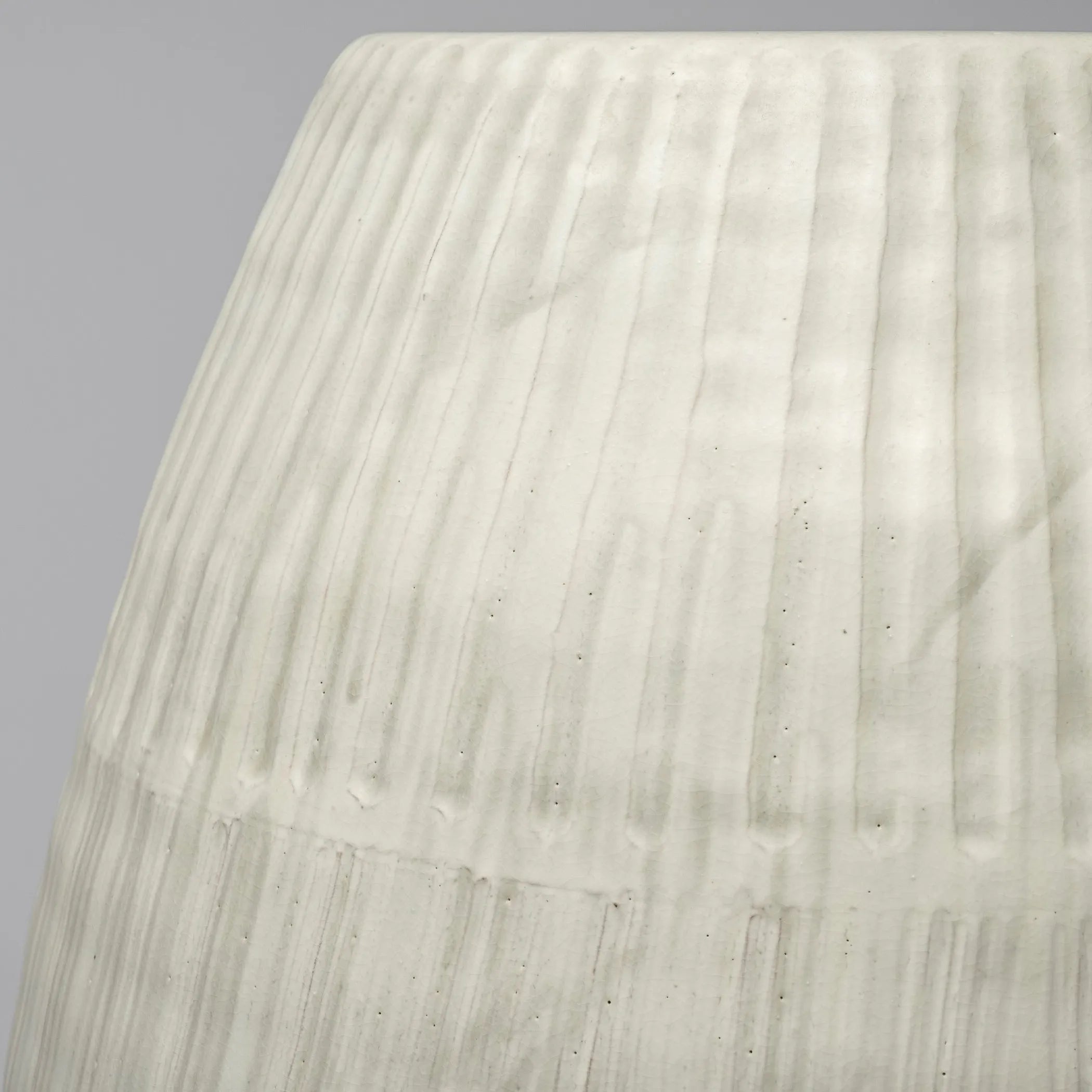 Close-up of a textured white surface with horizontal lines on a gray background