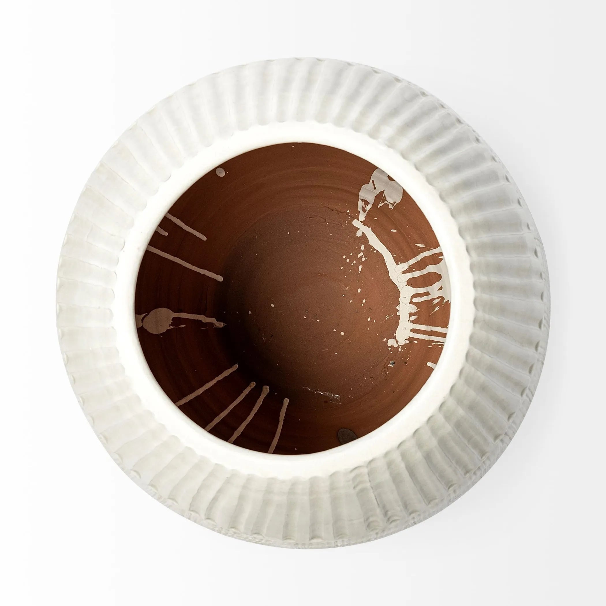 Close-up of the rim of an embossed white ceramic vase on a white background