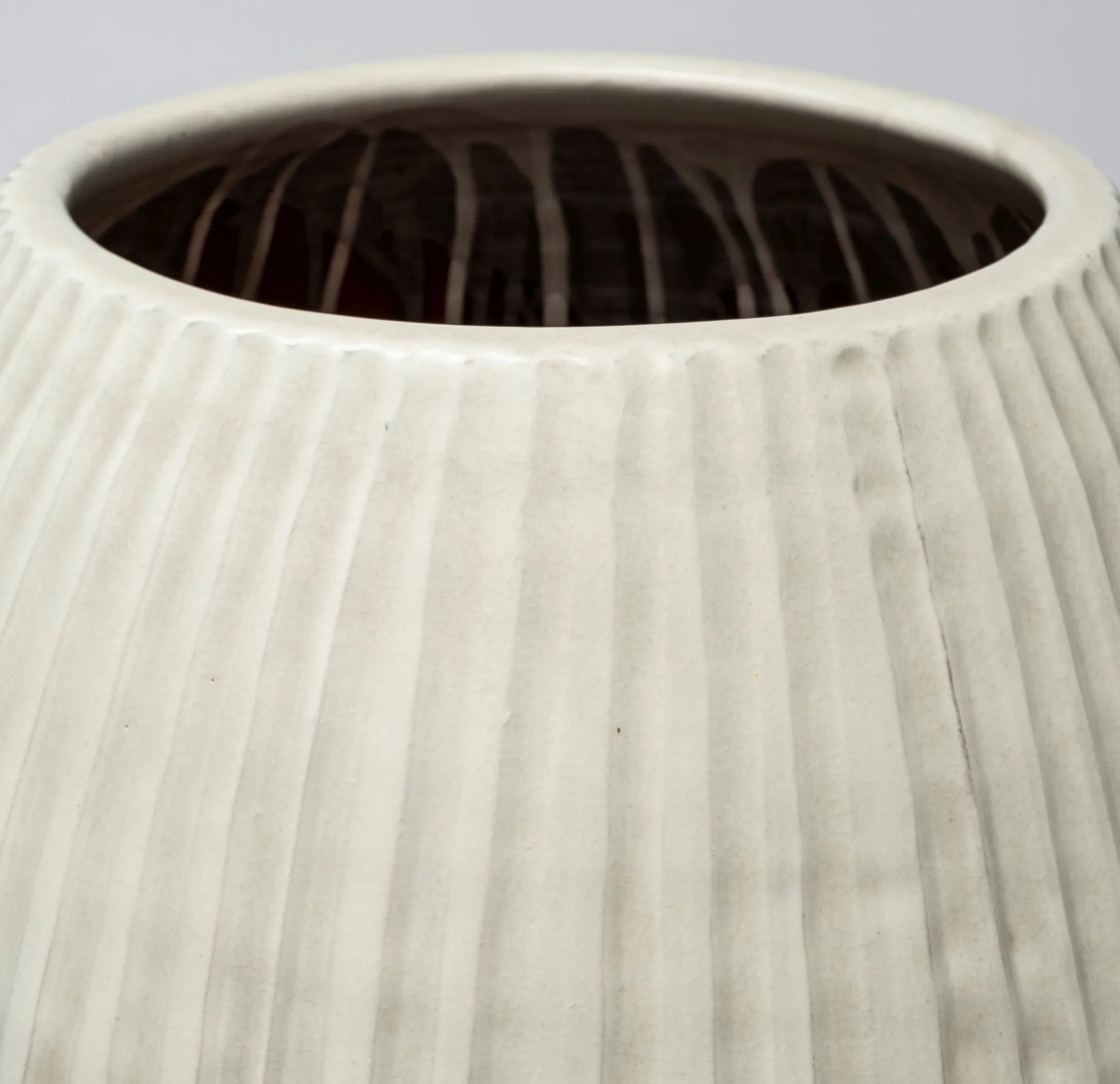 Close-up of a textured ceramic vase with a ribbed surface.