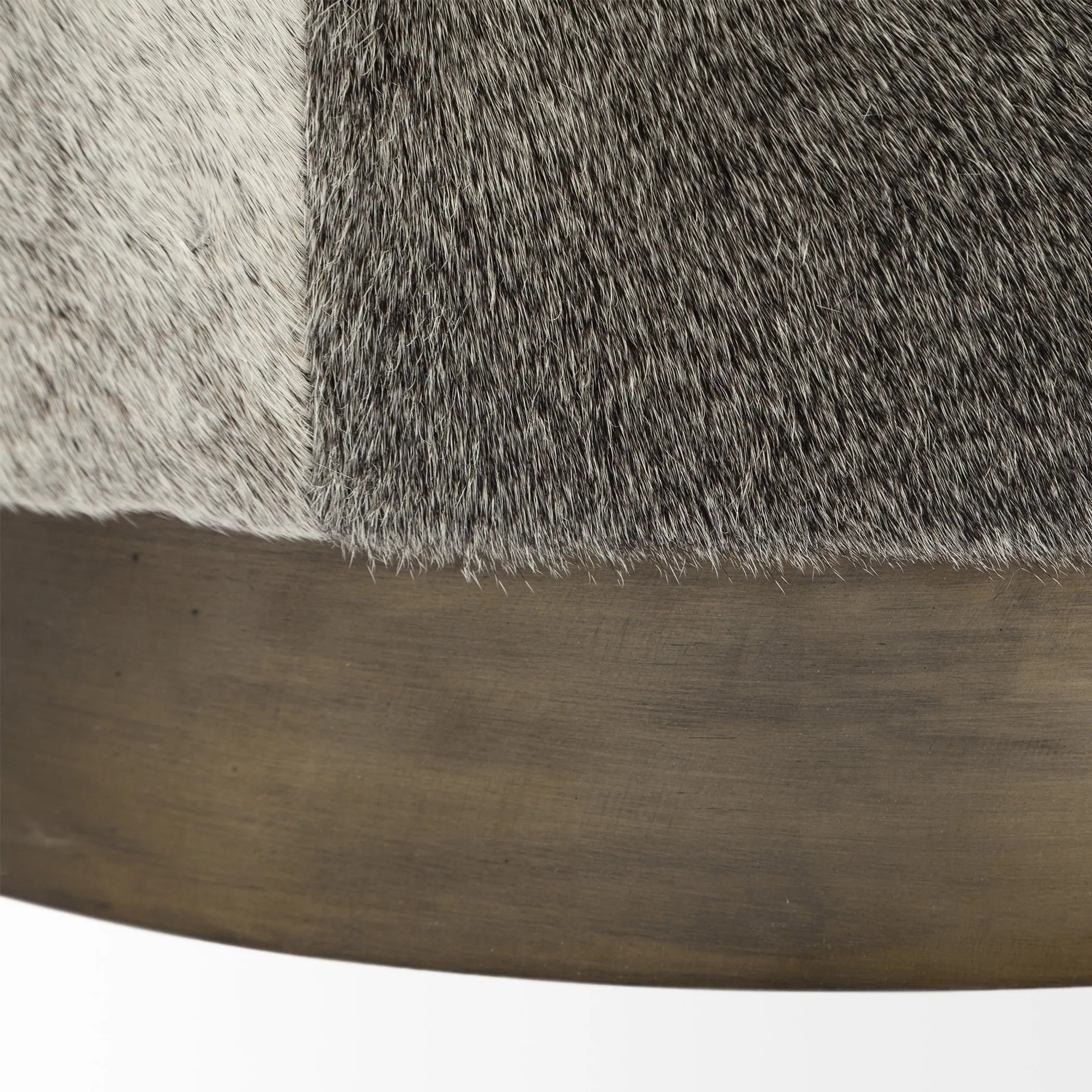 Close-up of the base of a gray brown wool upholstered ottoman.