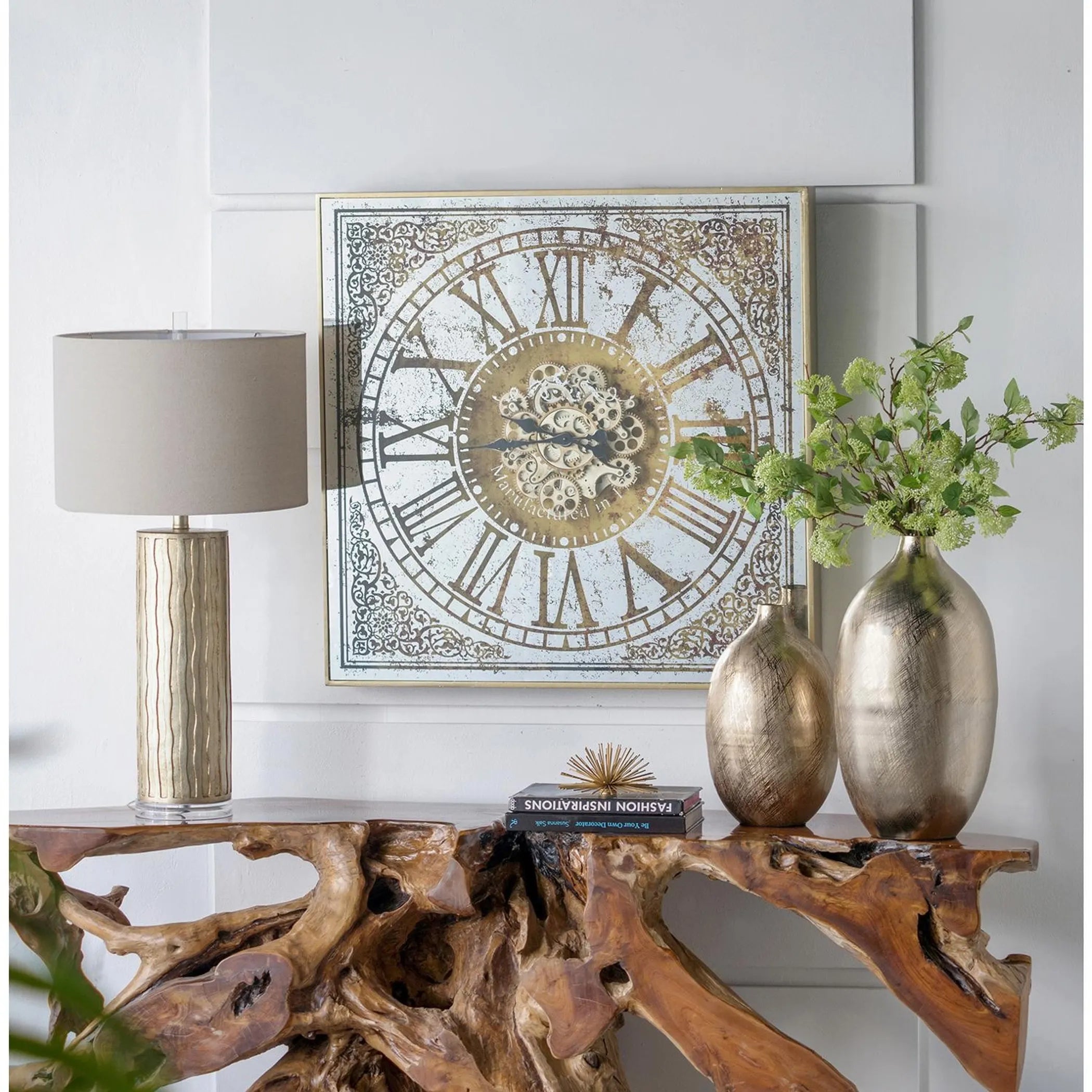 Decorative table with clock, lamp, and vases against a white wall
