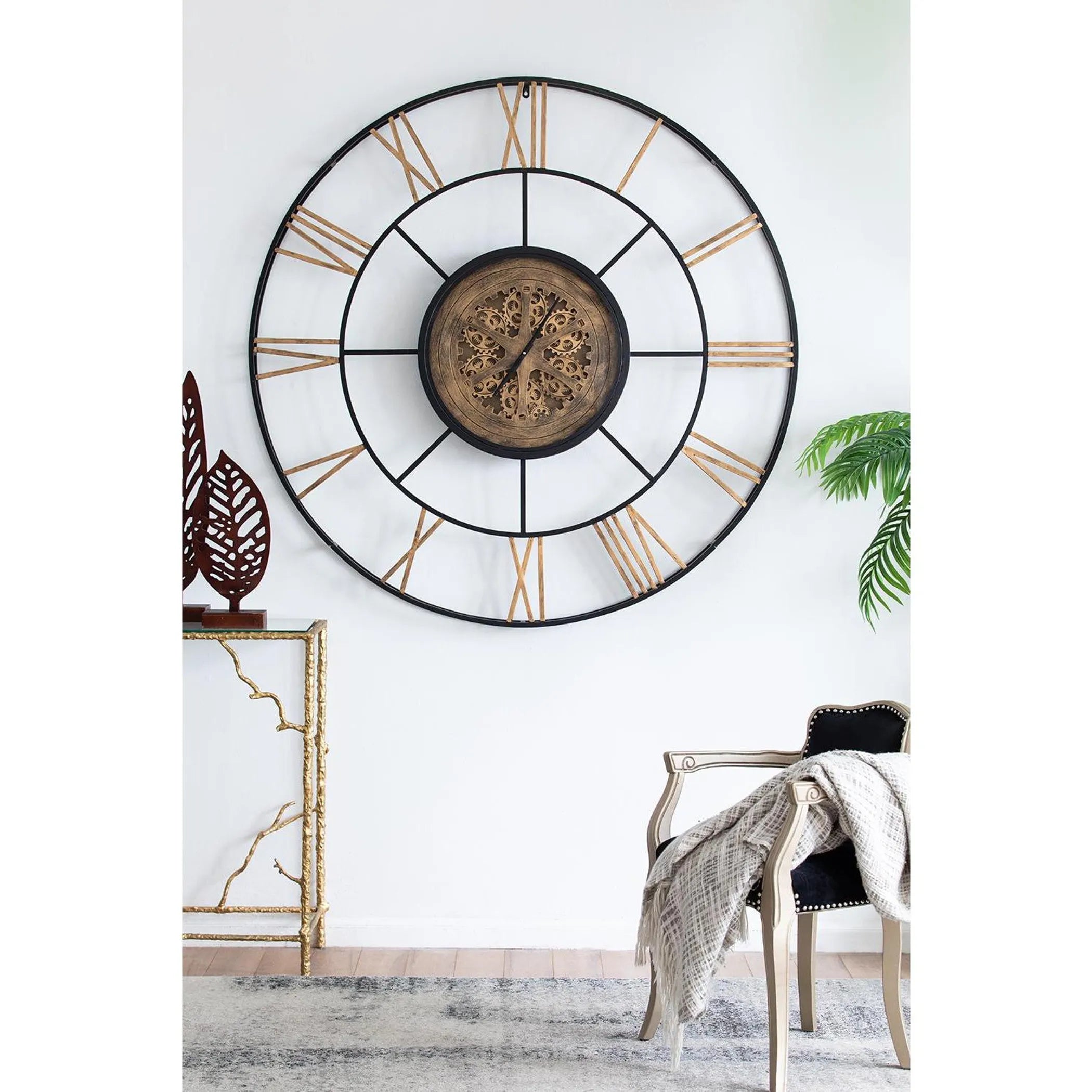 Large decorative wall clock with Roman numeral design on a white wall.