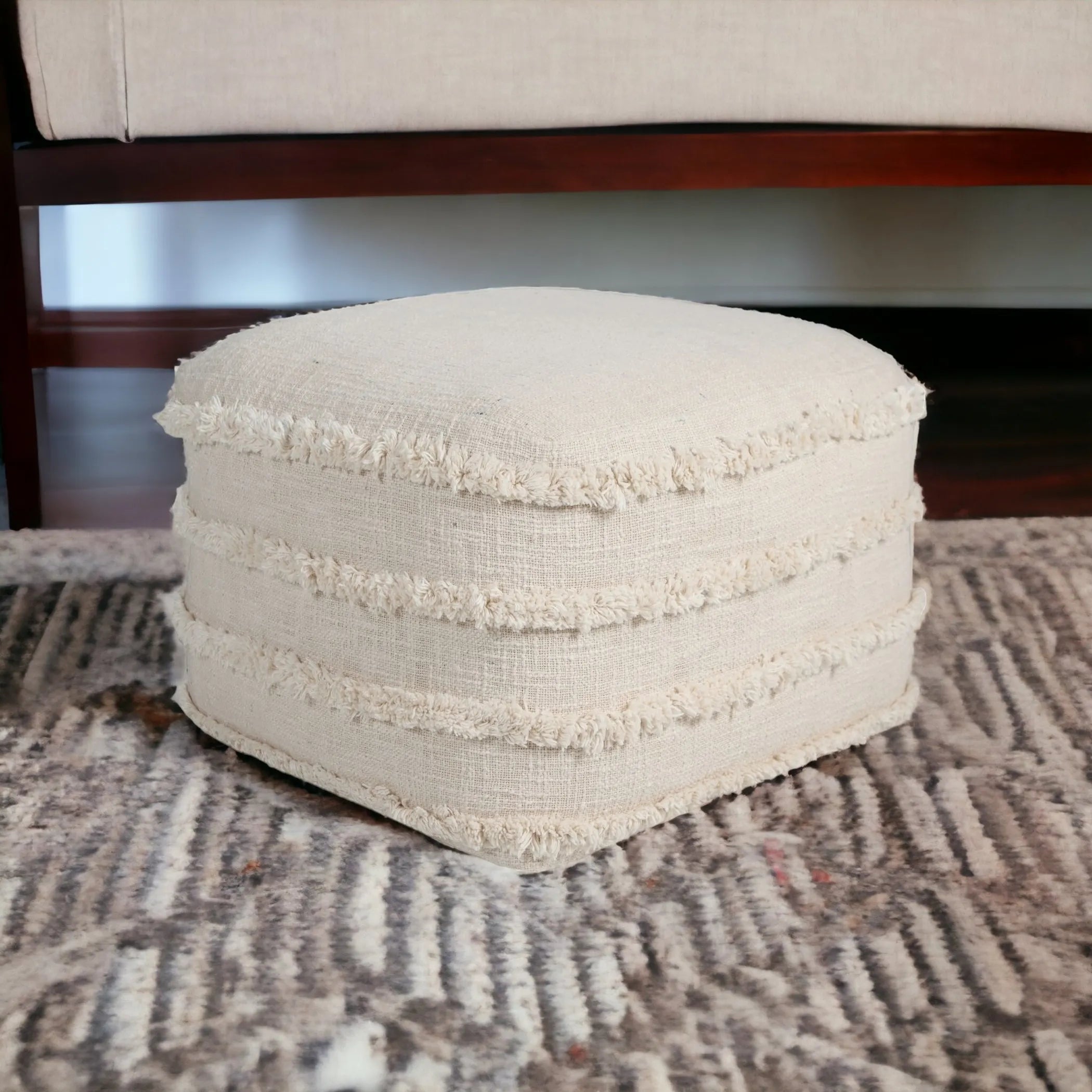Beige textured ottoman on a patterned rug