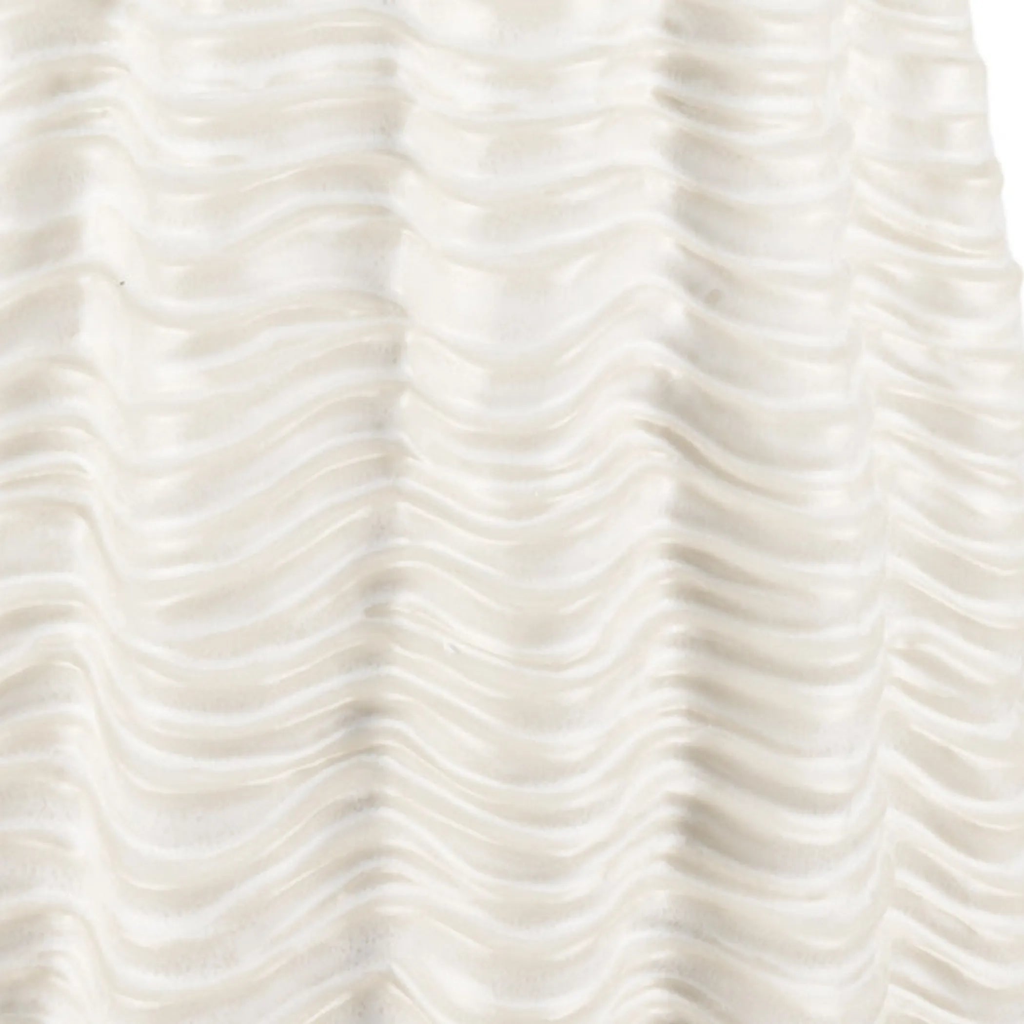 Close-up of textured white vase with wavy pattern