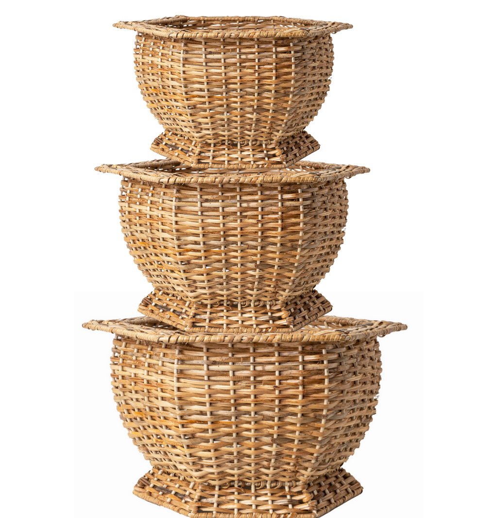 Set of three woven wicker planters stacked on a white background