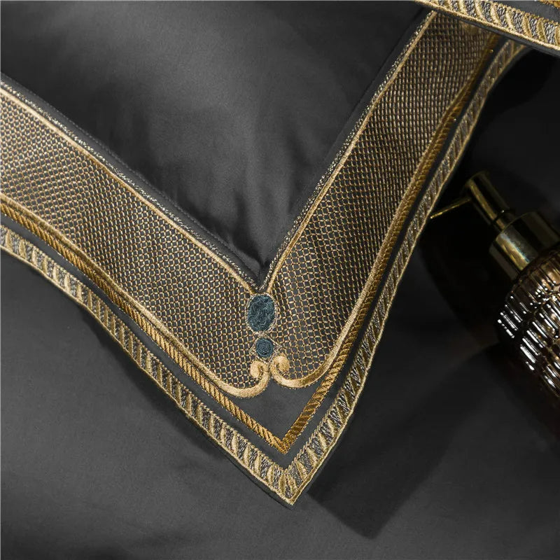 Close-up of a black pillow with gold embroidery on a dark background