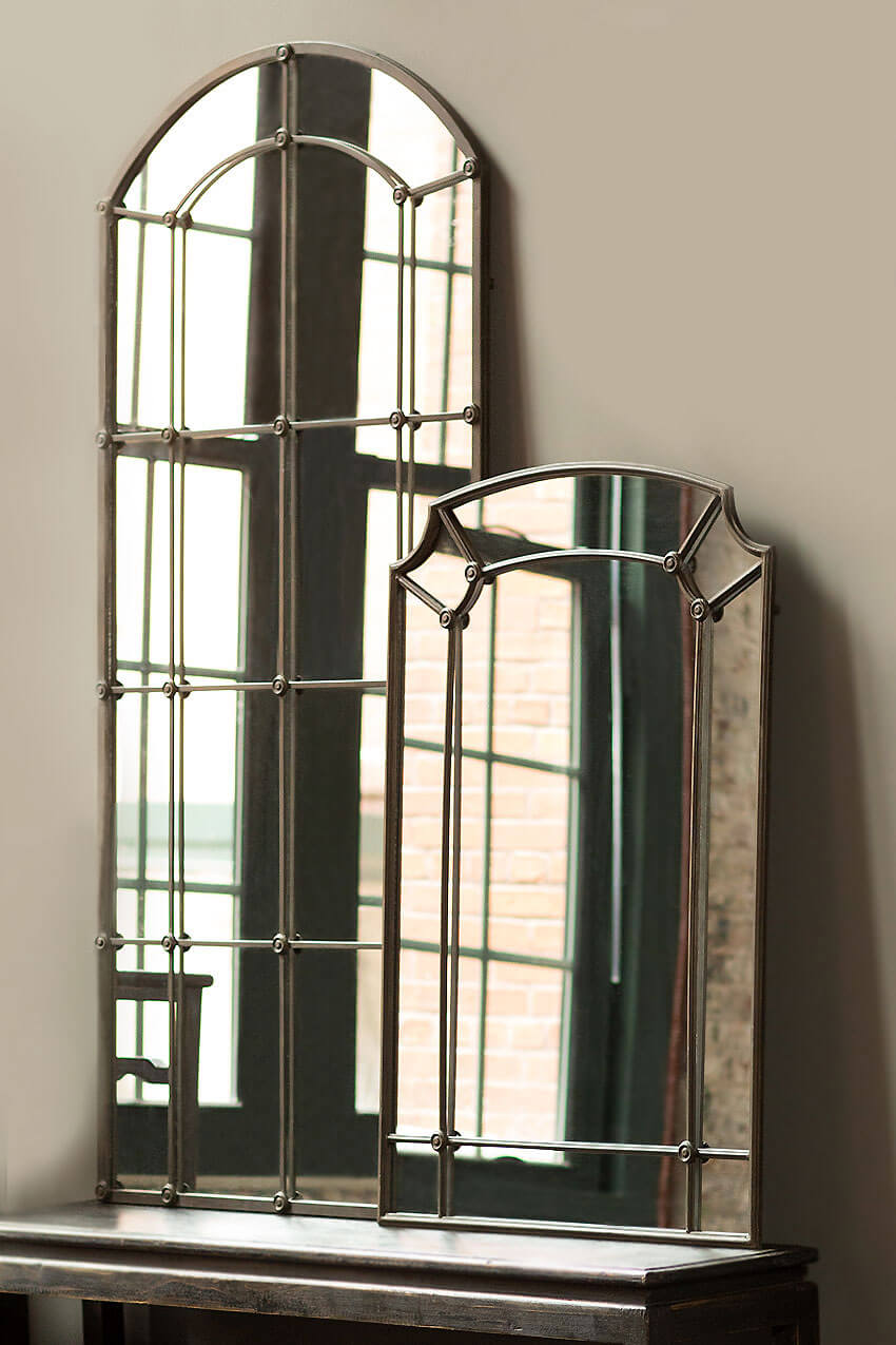 Two decorative mirrors with intricate frames on a wooden surface.