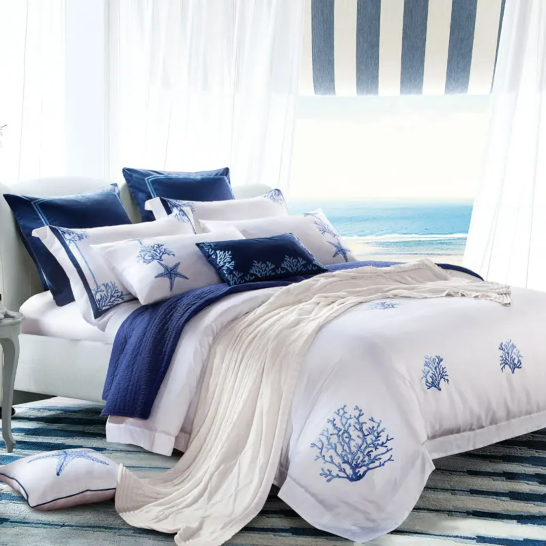 Nautical-themed bedroom with blue and white bedding featuring starfish and coral designs.