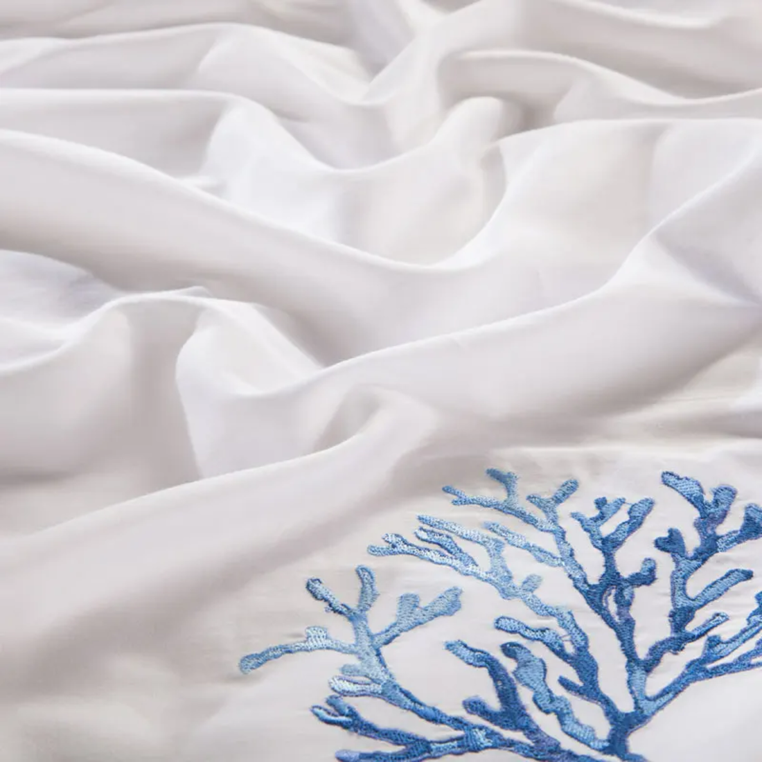 White fabric with blue embroidered coral design