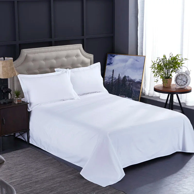 White bedspread on a bed in a bedroom setting with decor elements.