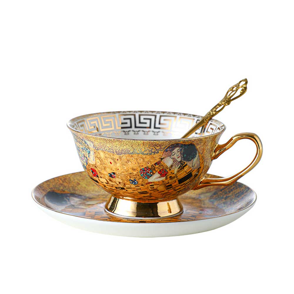 Decorative teacup with gold accents and a spoon on a white background