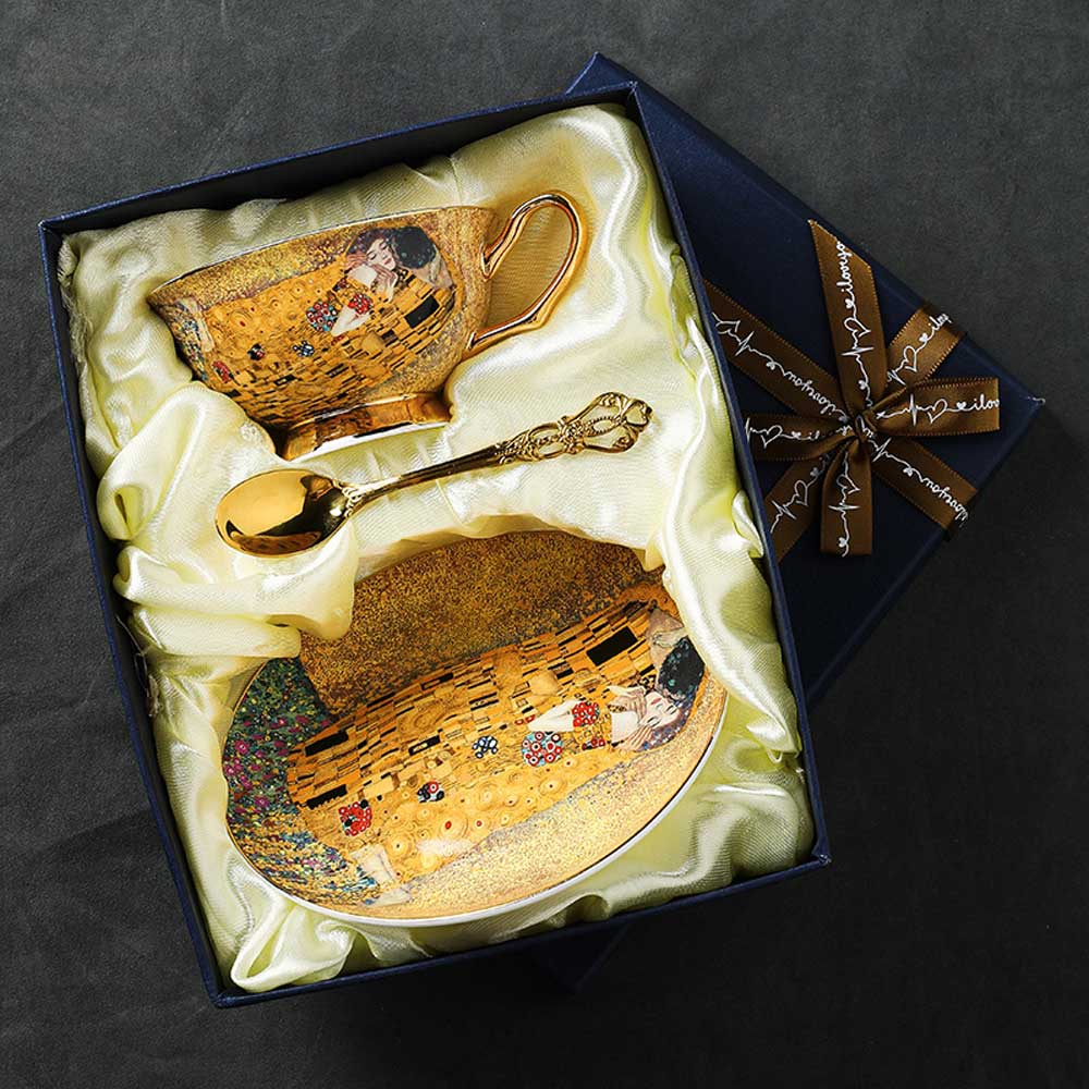 Decorative cup and spoon set with artistic design in a gift box on a dark background