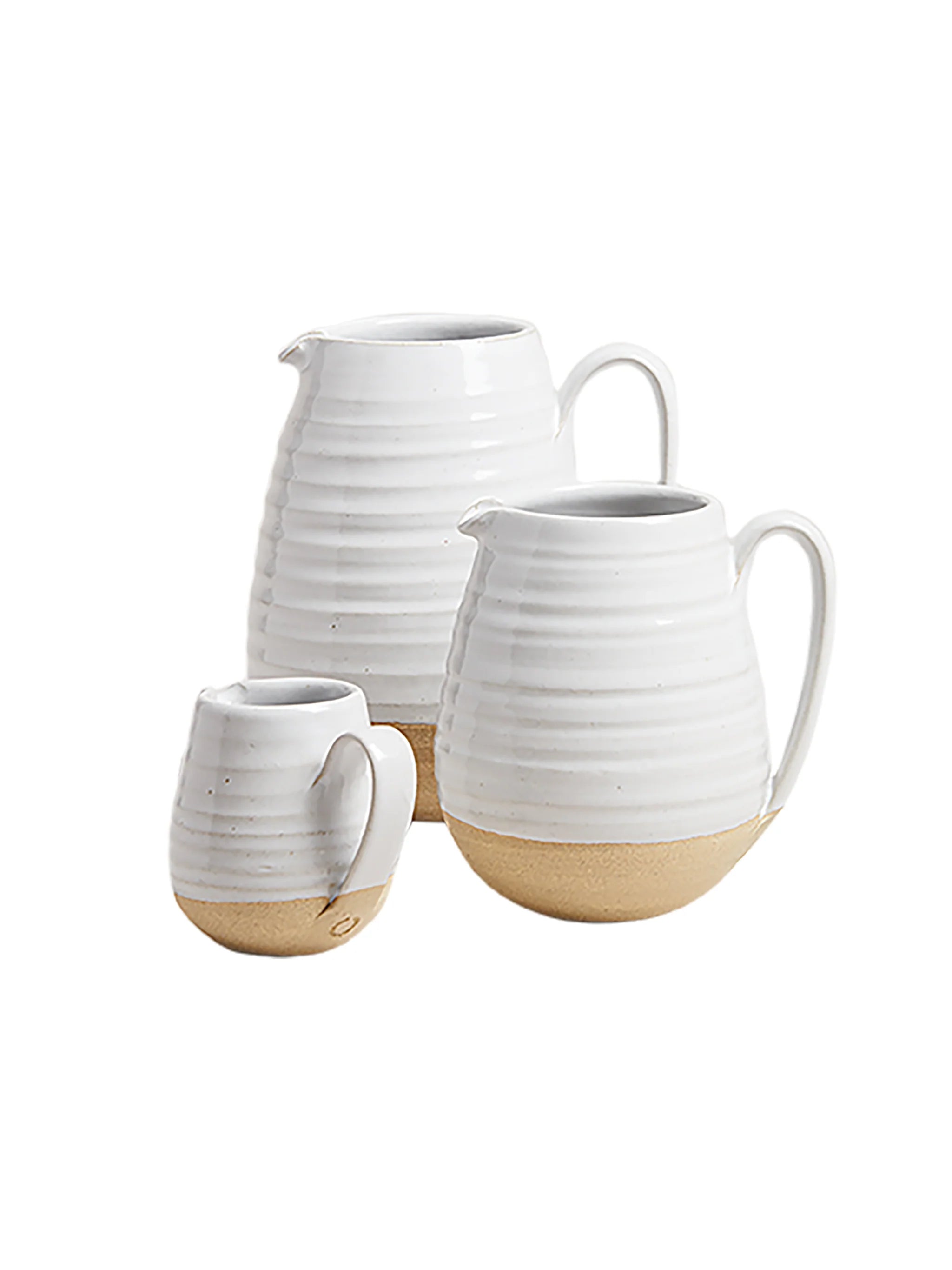 Set of three ceramic pitchers with white and beige finishes on a white background