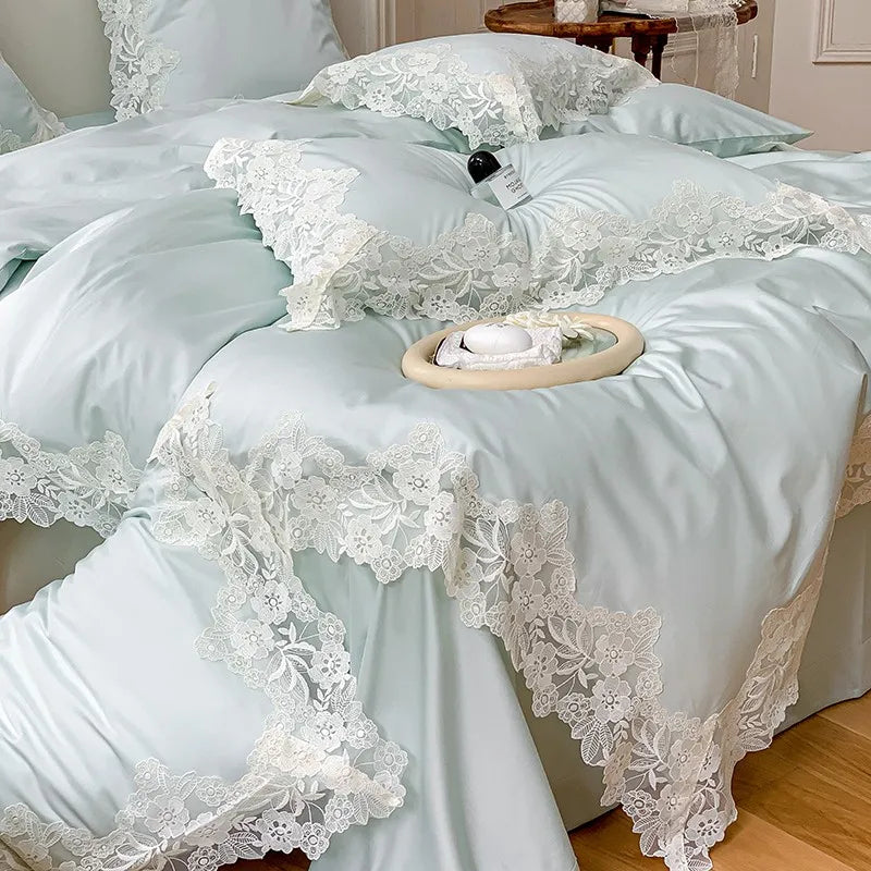 Light blue bedding set with lace details on a bed.