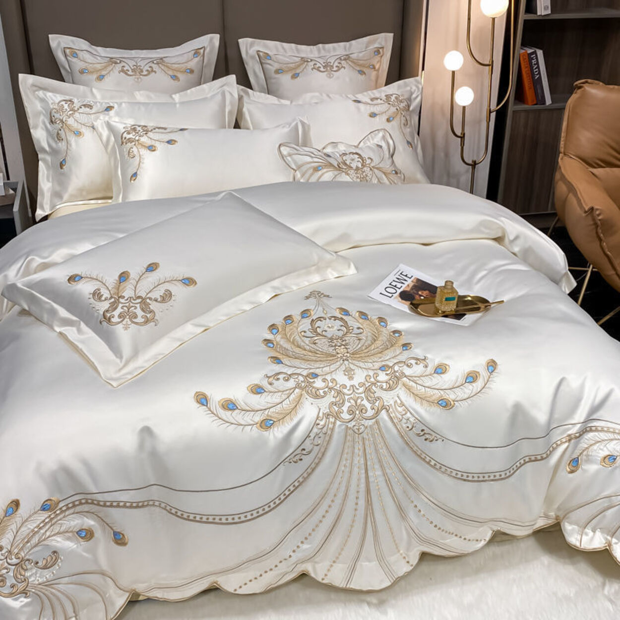 Luxurious white bedspread with gold embroidery in a bedroom setting.