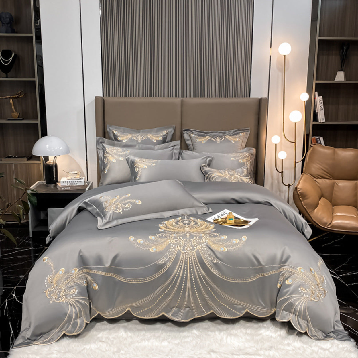 Gray bedding set with gold embroidery on a bed in a modern bedroom.