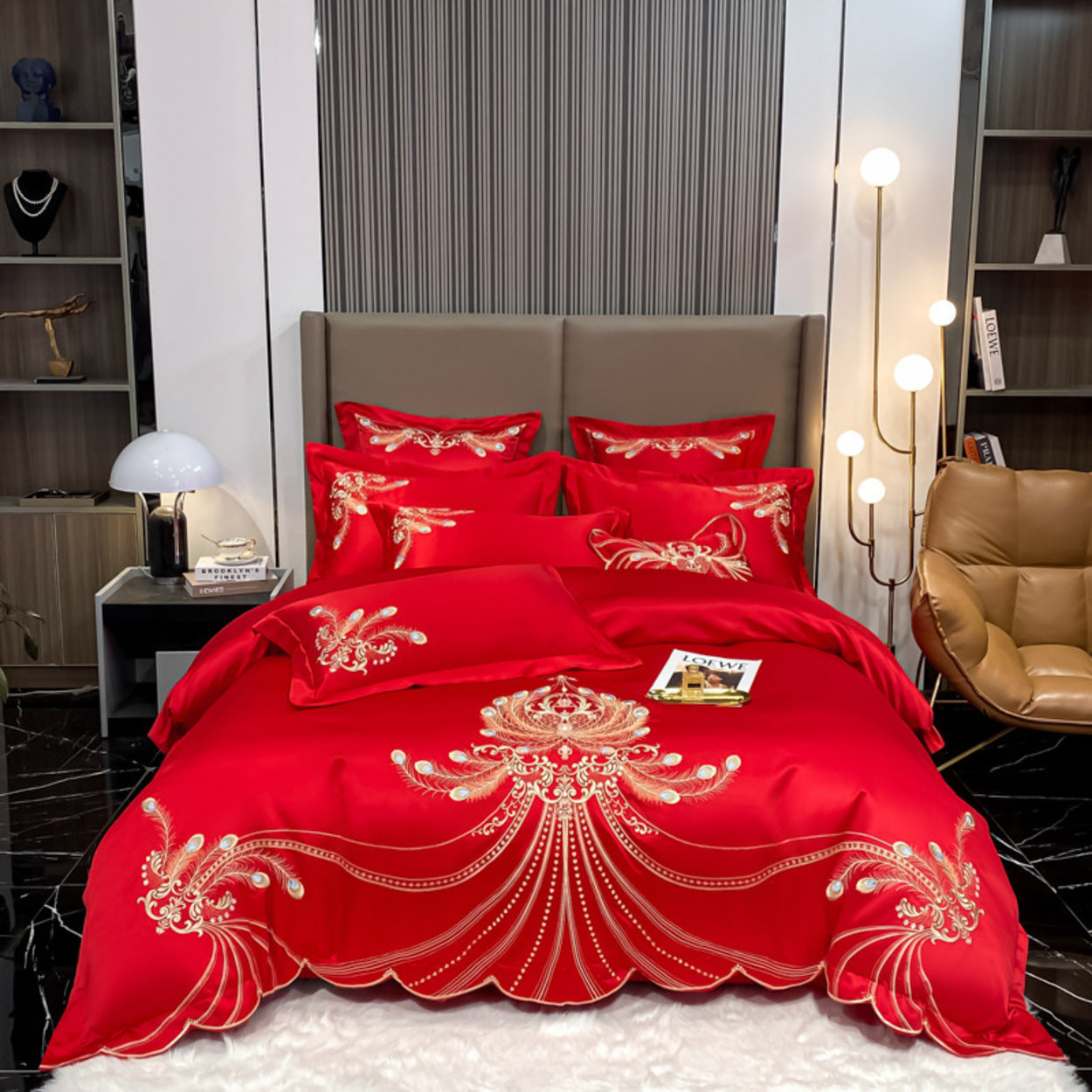 Red embroidered bedding set on a bed in a modern bedroom.